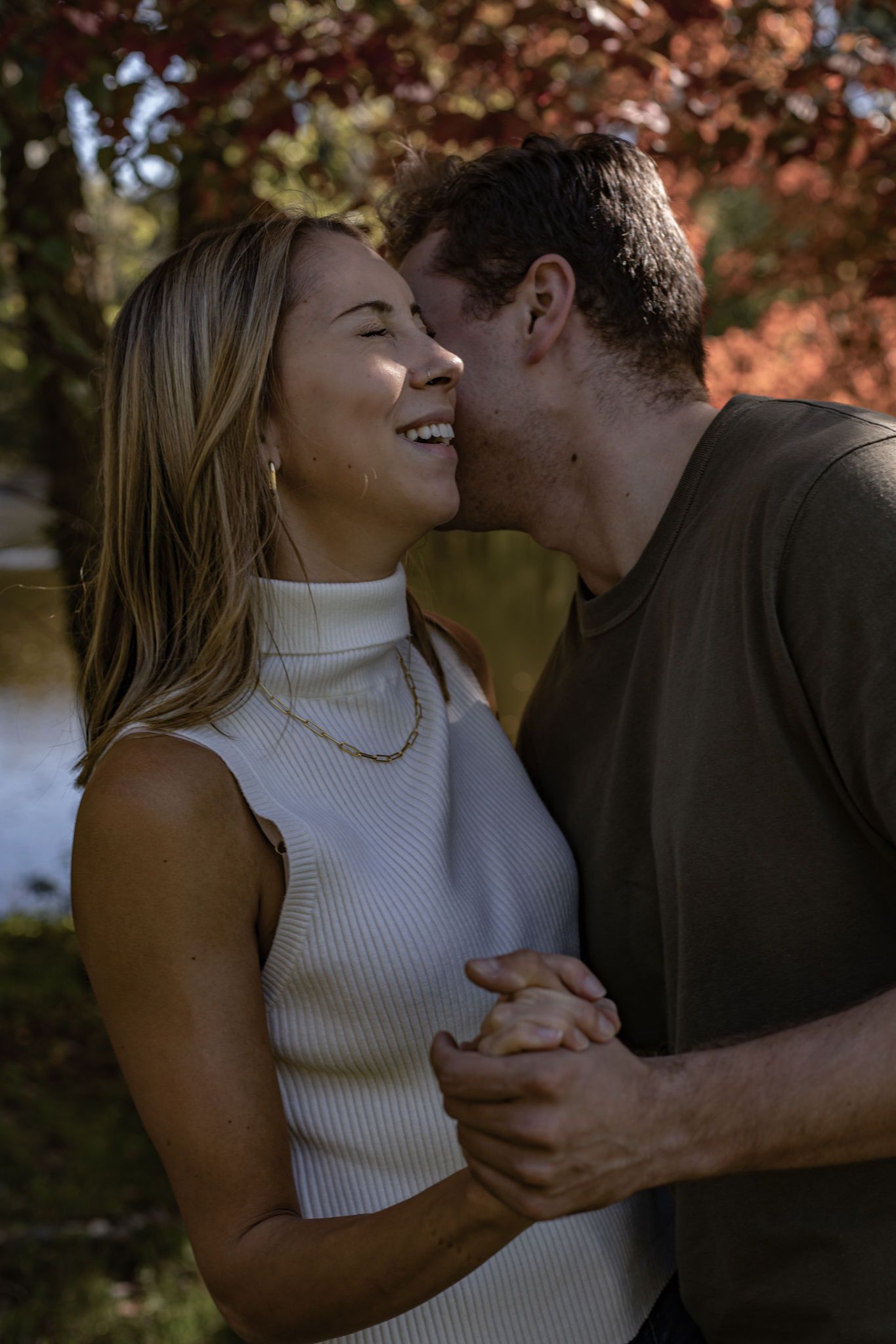 A couple sharing a tender moment outdoors during golden hour.