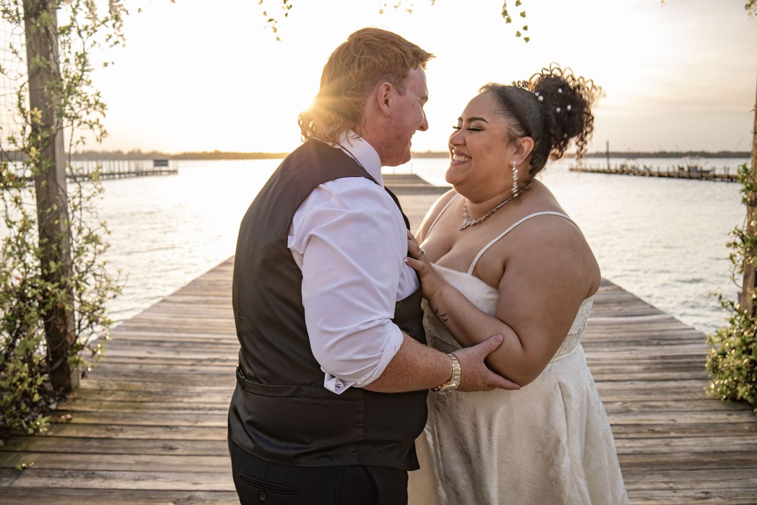 Intimate wedding moment captured at sunset on a waterfront dock.