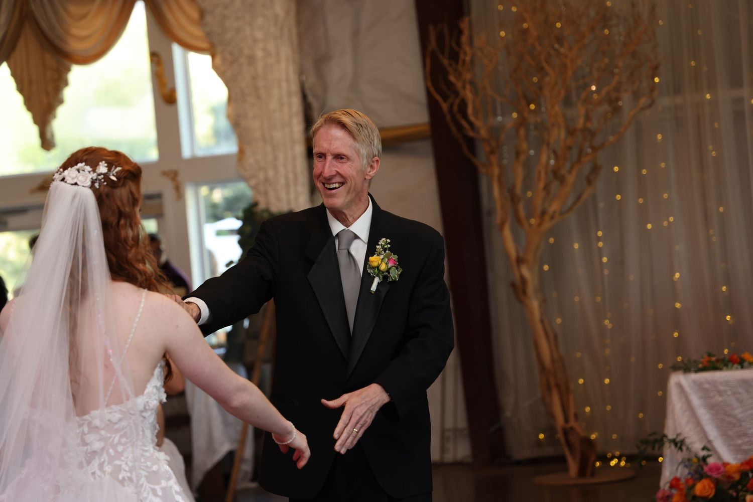 Wedding reception moment with couple dancing in elegantly decorated indoor venue.
