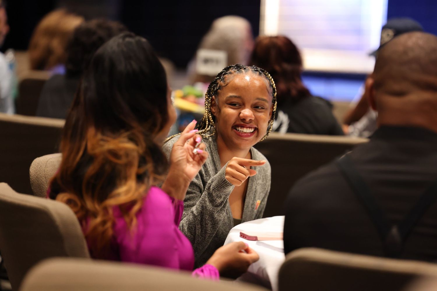 Members of a church congregation sharing joyful laughter during a service gathering.