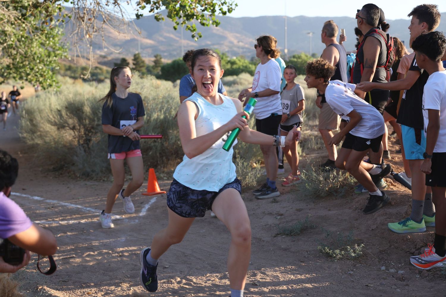 Runners gathered at a desert trail race cheering and celebrating.
