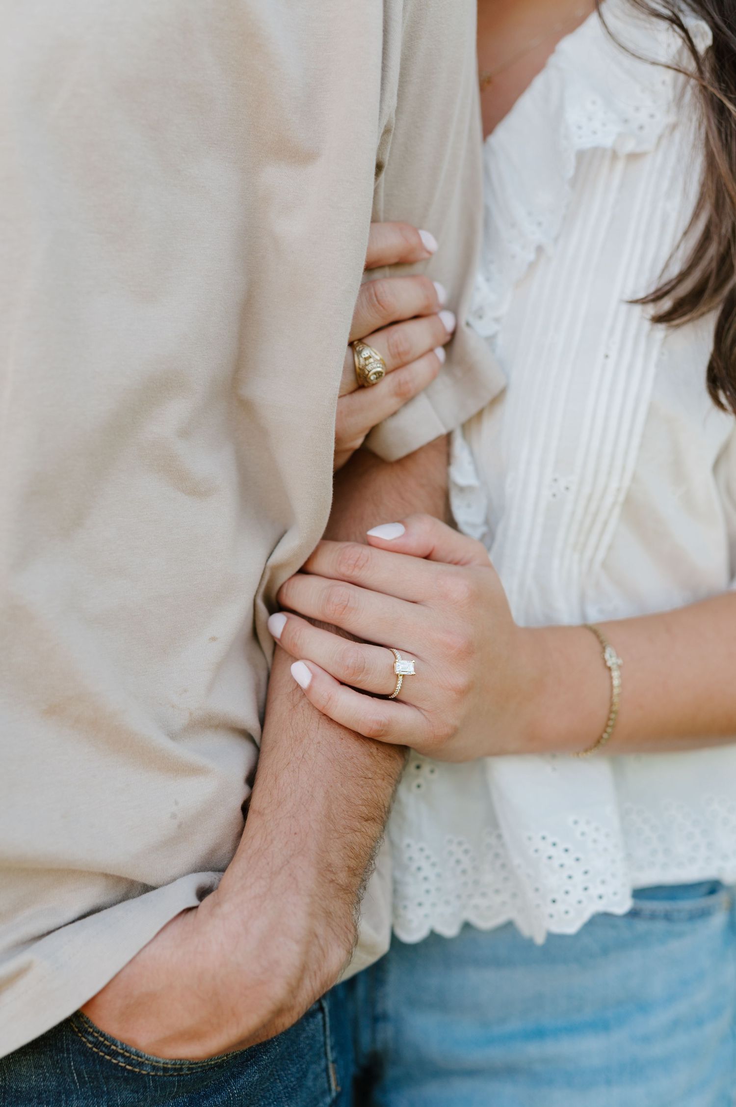 Close-up detail shots of hands showing an engagement ring and bracelet against white and beige clothing.