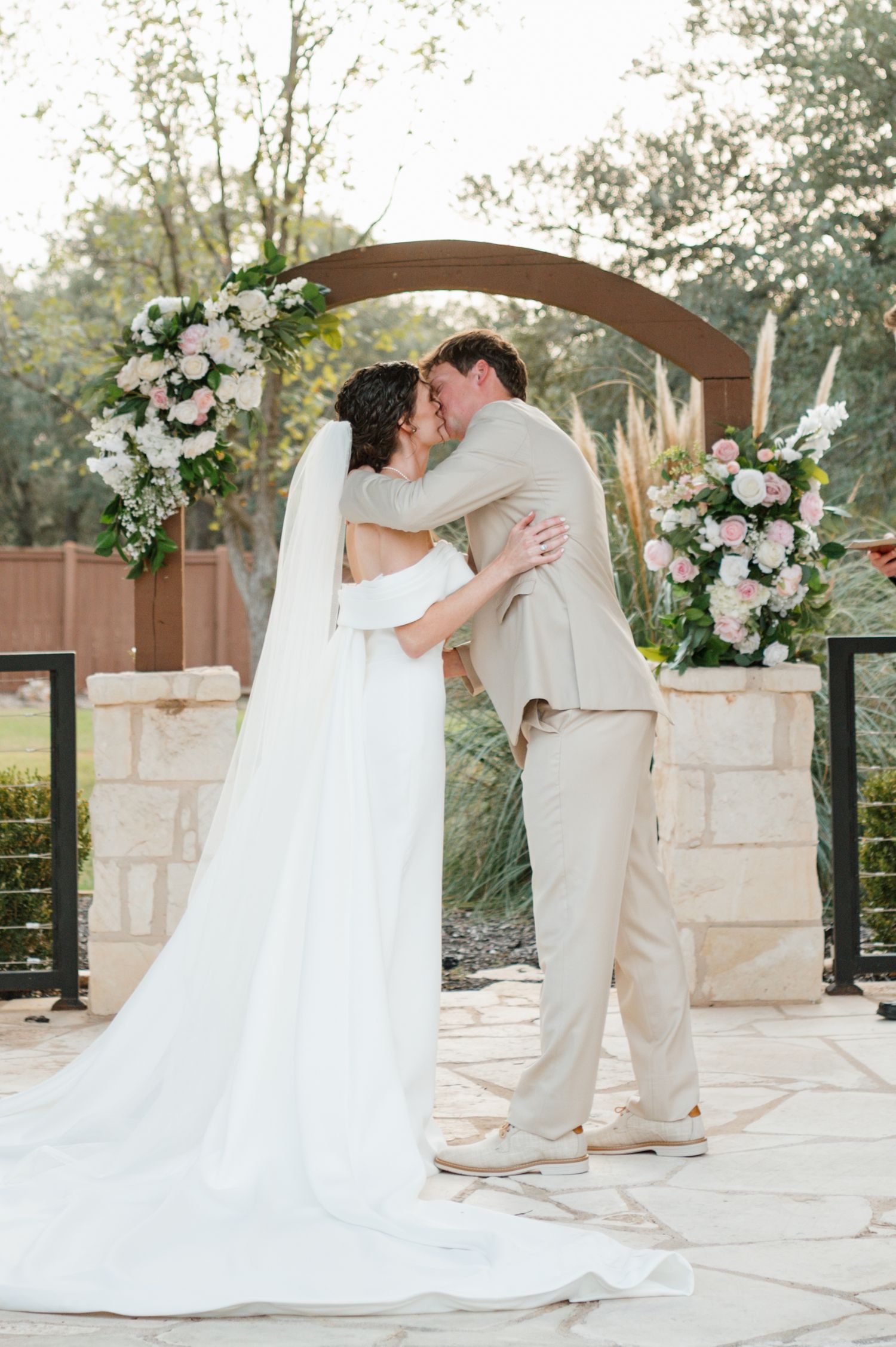 A romantic wedding sequence shows a couple in white and khaki sharing sweet moments on a stone patio with floral decor.