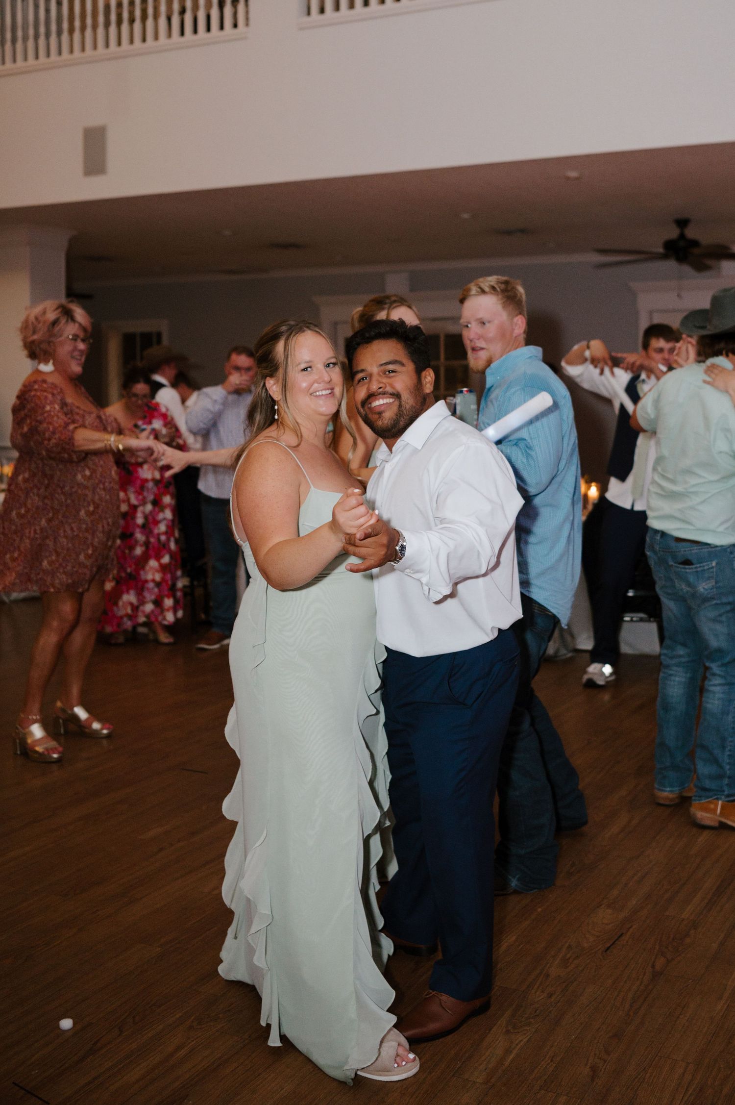 Couple sharing a romantic slow dance on the wooden dance floor.