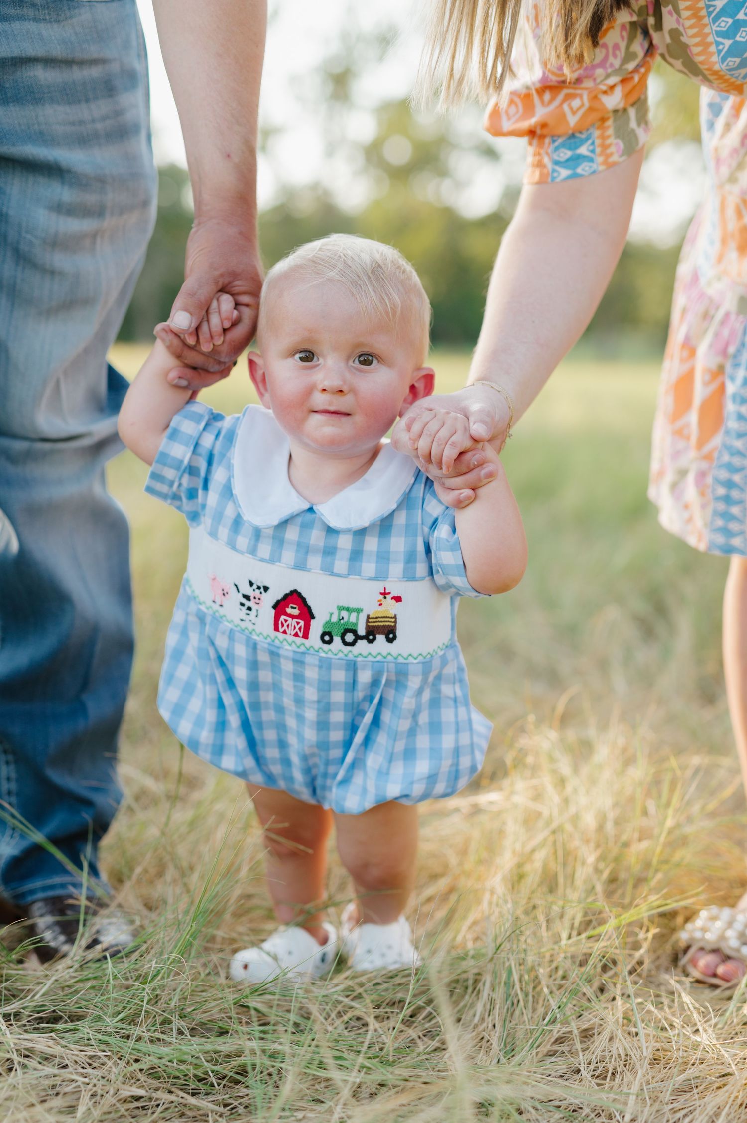 A series of photos showing small feet in blue and white gingham clothing standing in golden grass at sunset.