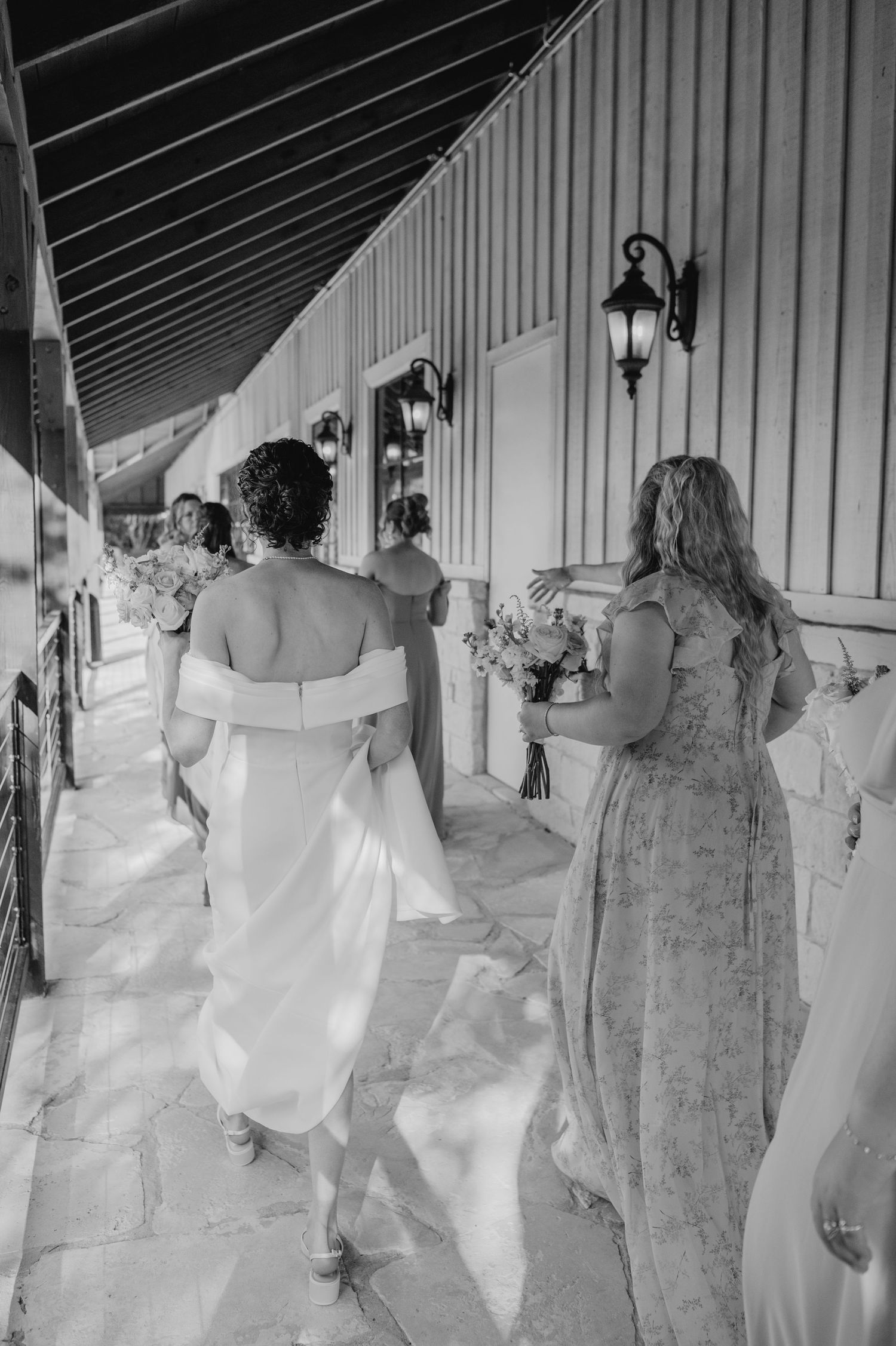 Black and white photo series showing bridesmaids in formal dresses standing in a rustic venue.