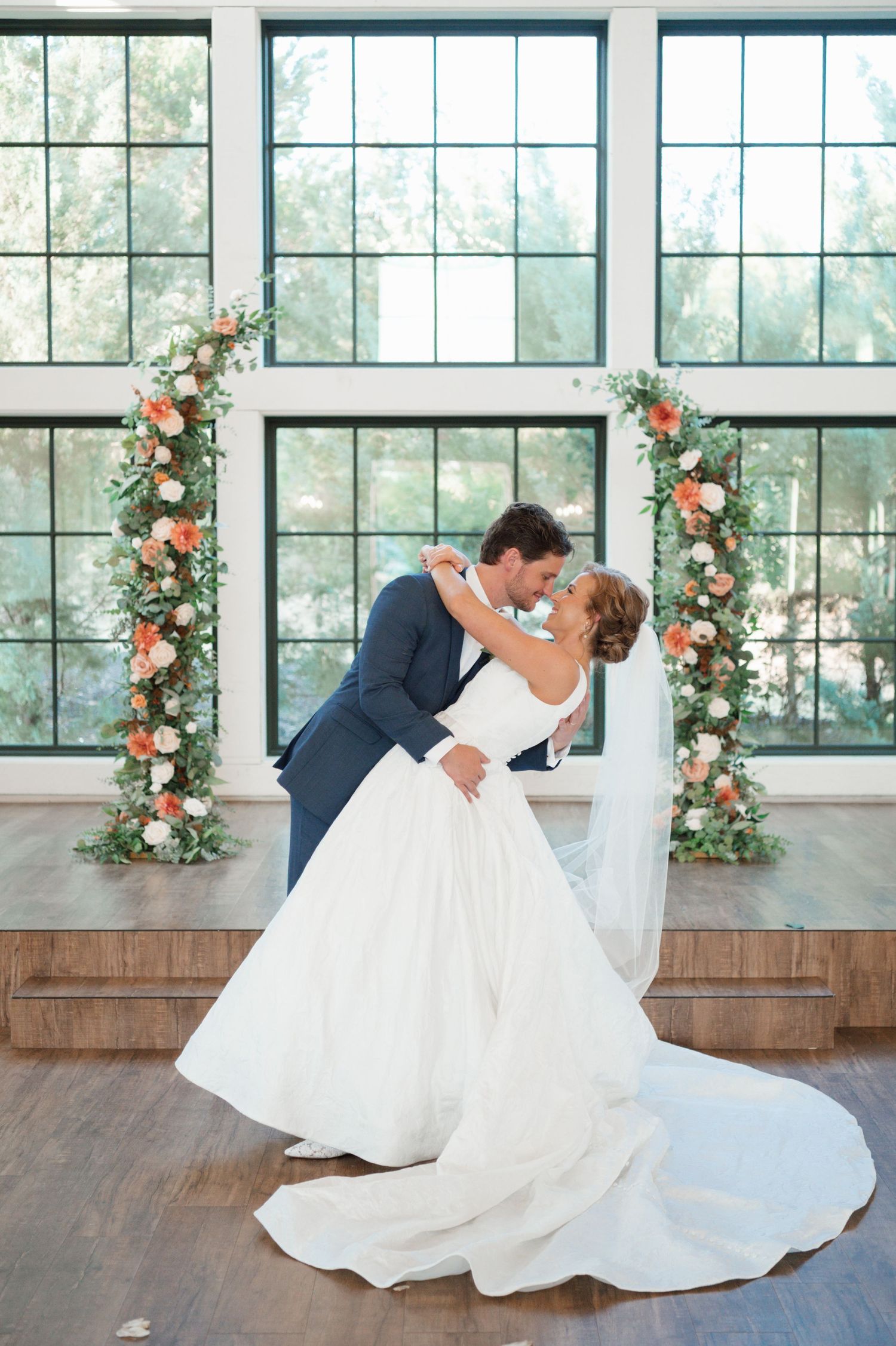 Romantic first dance sequence shows couple twirling in an elegant venue decorated with floral window arrangements.