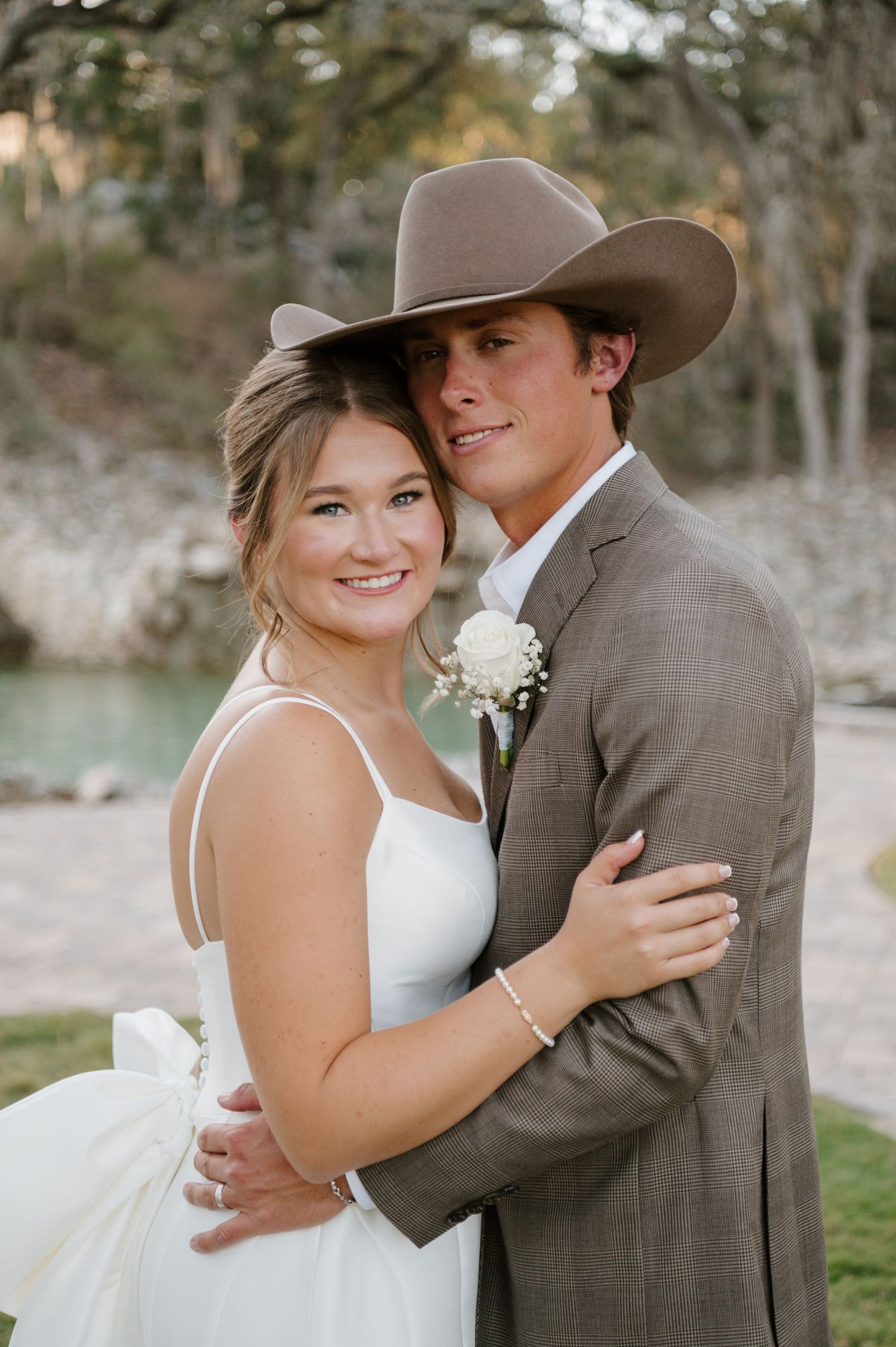 A couple poses at their rustic, Texas wedding in the Texas Hill Country at Hidden Falls Hayes Hollow.
