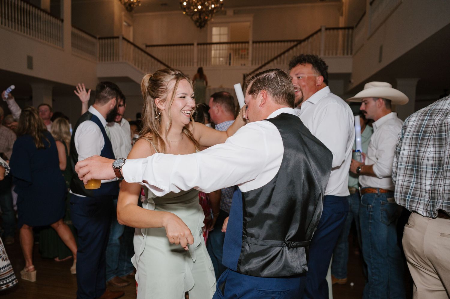 Wedding guests enjoying themselves during an energetic dance party reception.