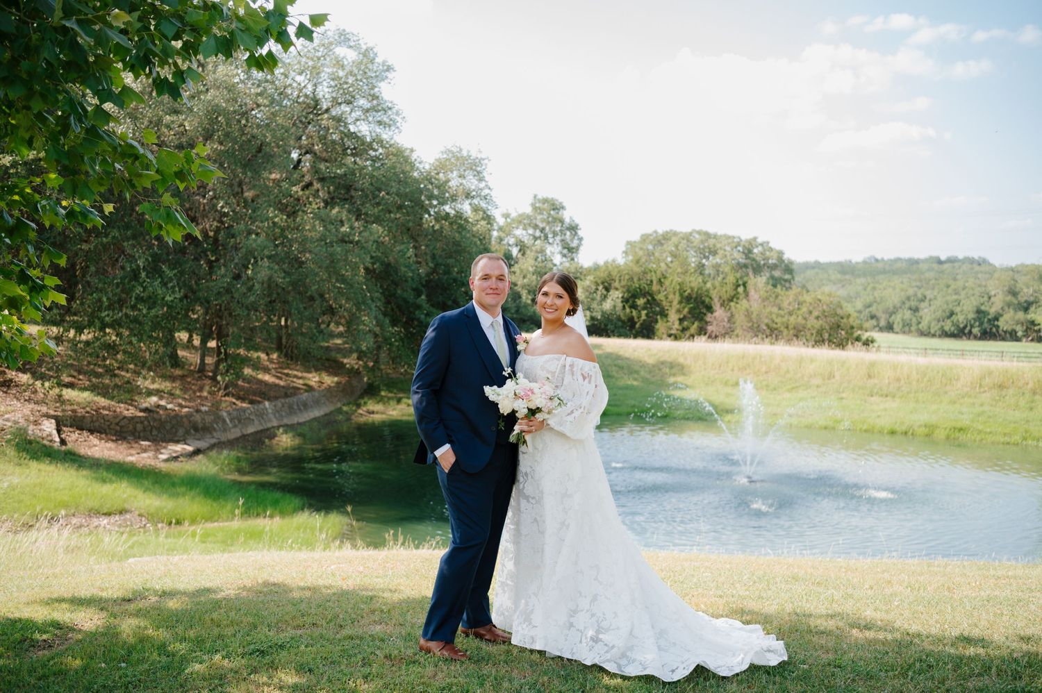 A couple celebrates their wedding day with scenic outdoor photos along a serene waterfront setting in nature.