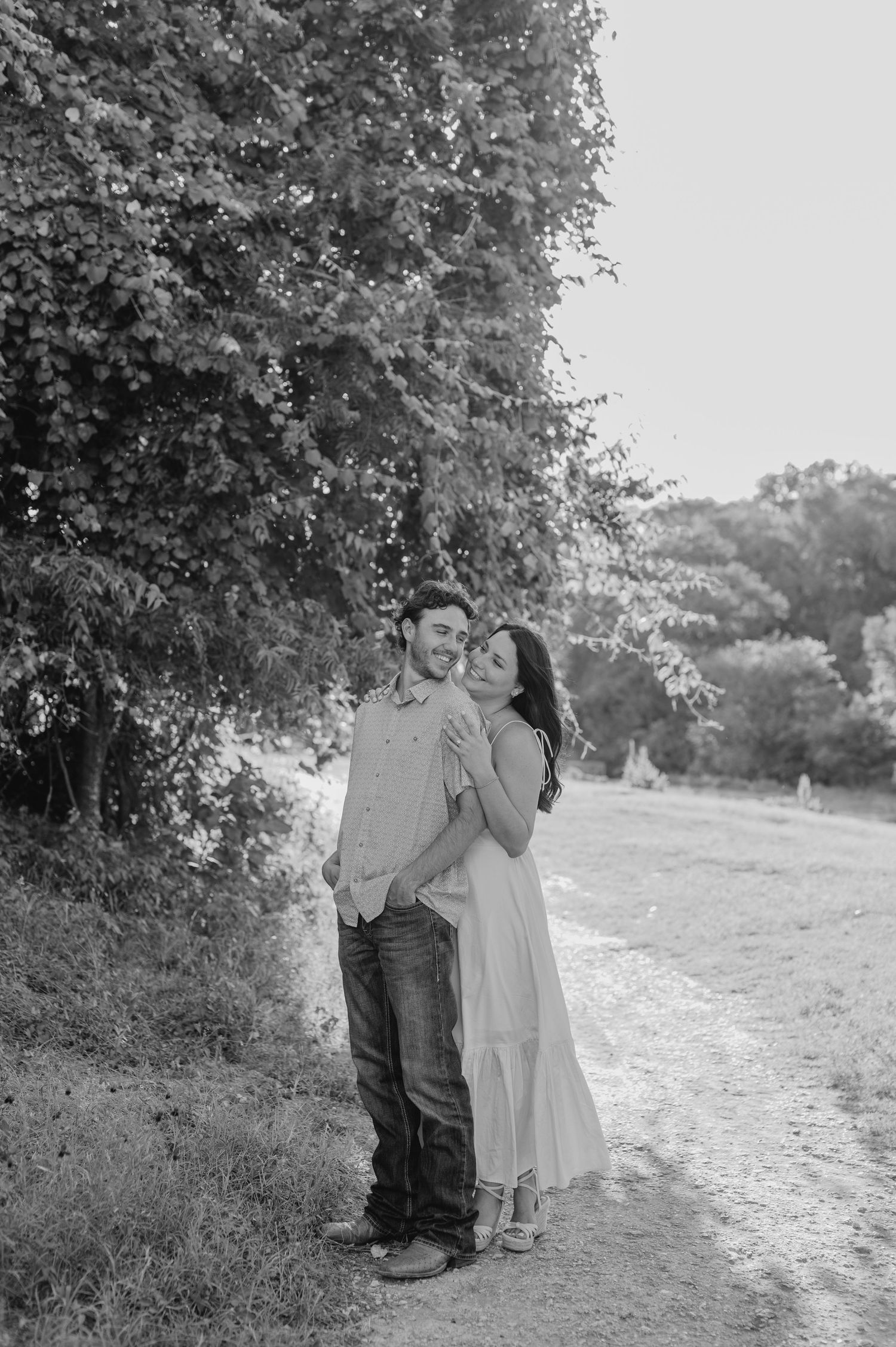 A black and white portrait of a couple standing together on a winding path.