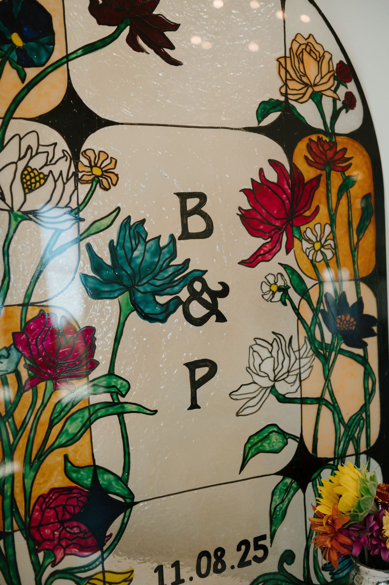Colorful floral wall art with vibrant painted flowers and greenery against a light background with a date shown.