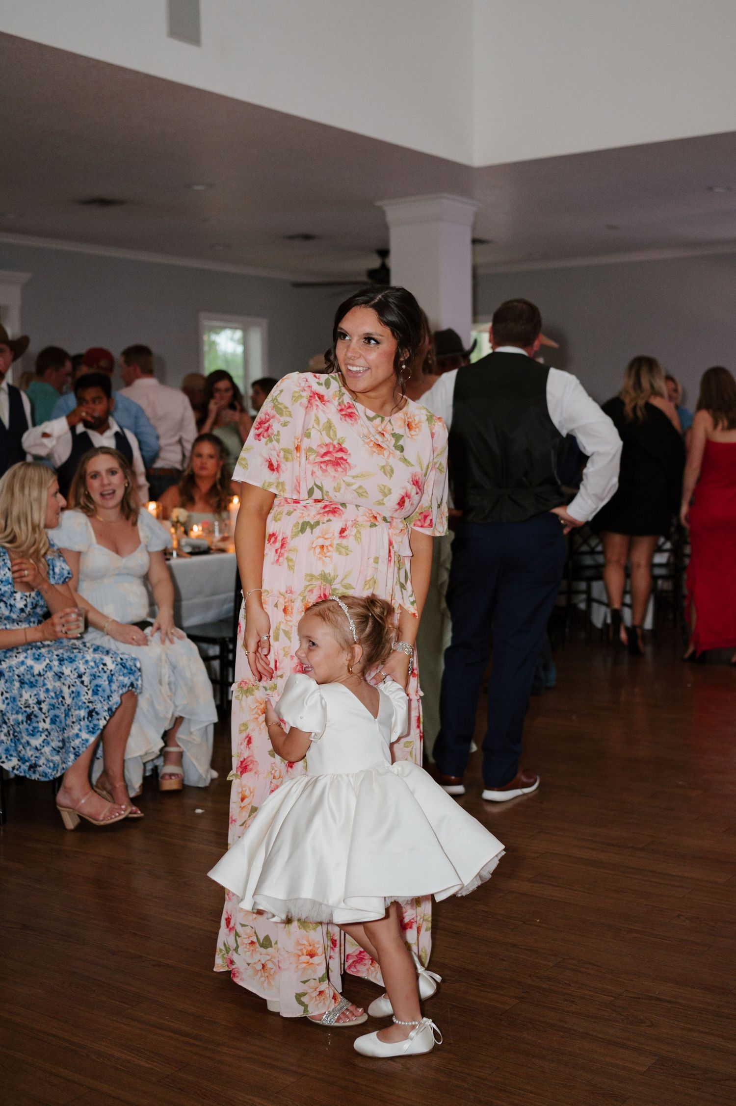 Reception guests dancing and celebrating on a wooden dance floor.