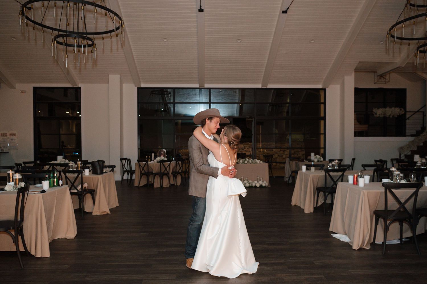 Wedding couple dancing in a dimly lit reception venue sharing their private last dance in Texas photographed by Alyssa Denson Photography.
