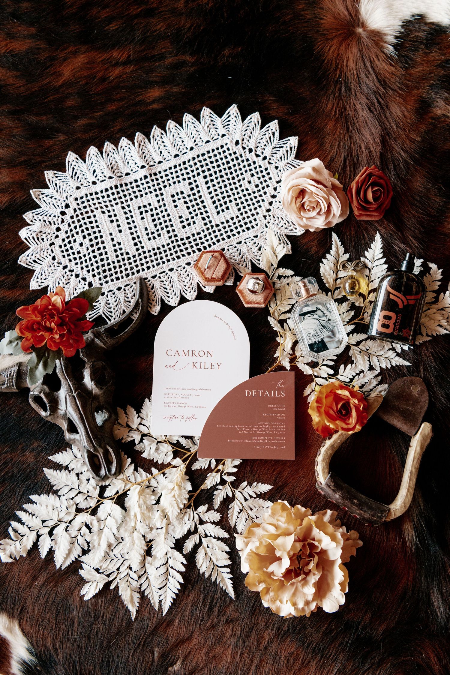 Wedding details with lace doily, invitations, and floral decorations arranged on brown fur backdrop.