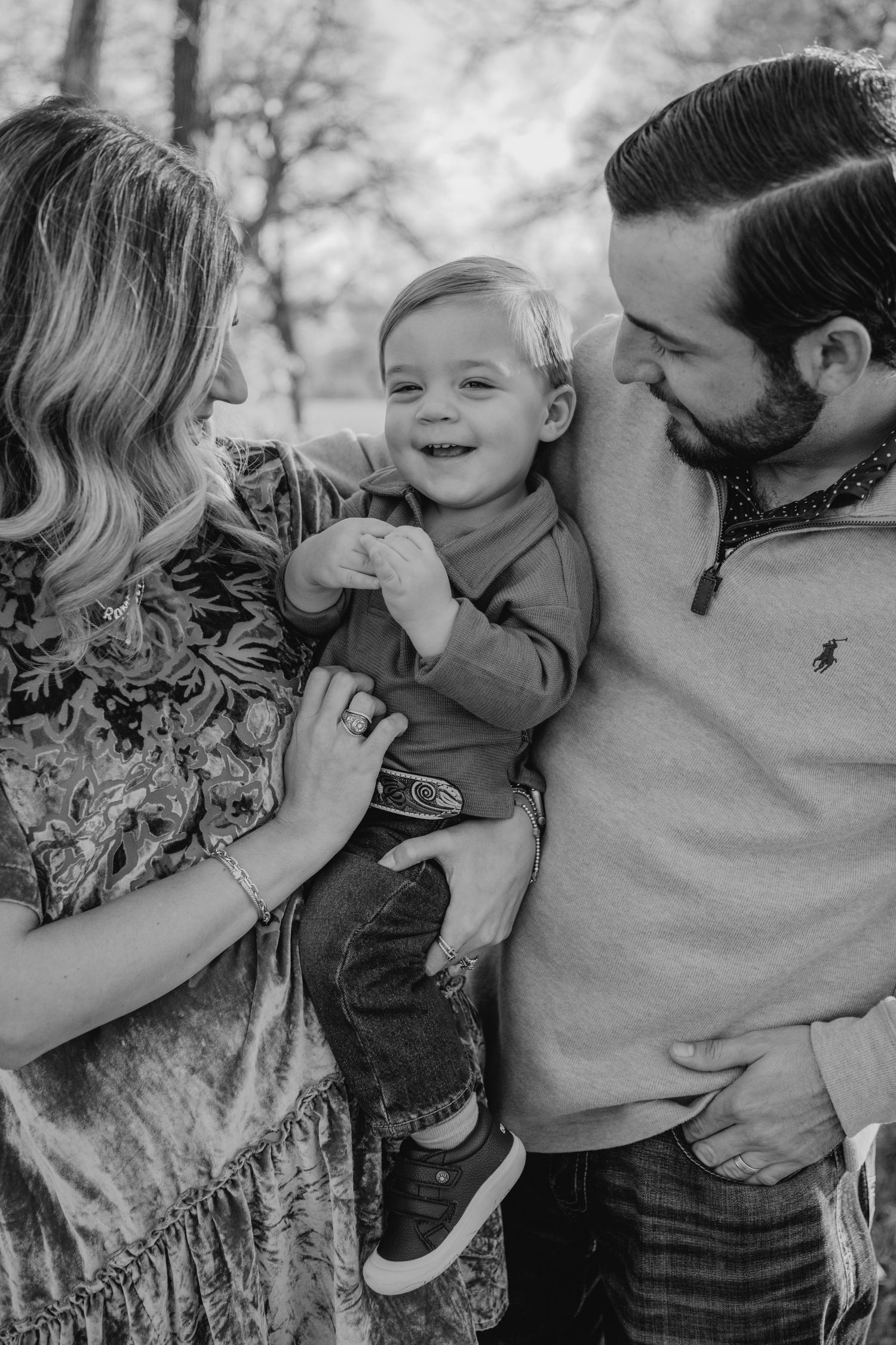 A black and white photo series showing a family sharing joyful moments and embraces together outdoors.
