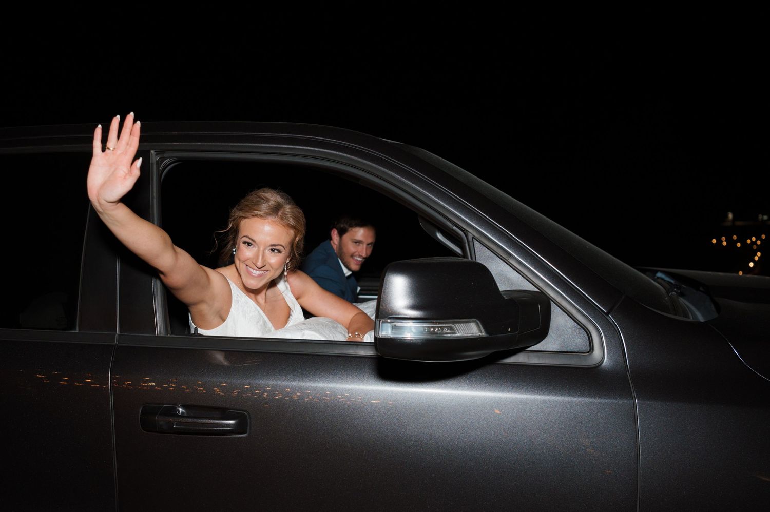 A sequence of photos showing someone waving from inside a dark colored car at night.
