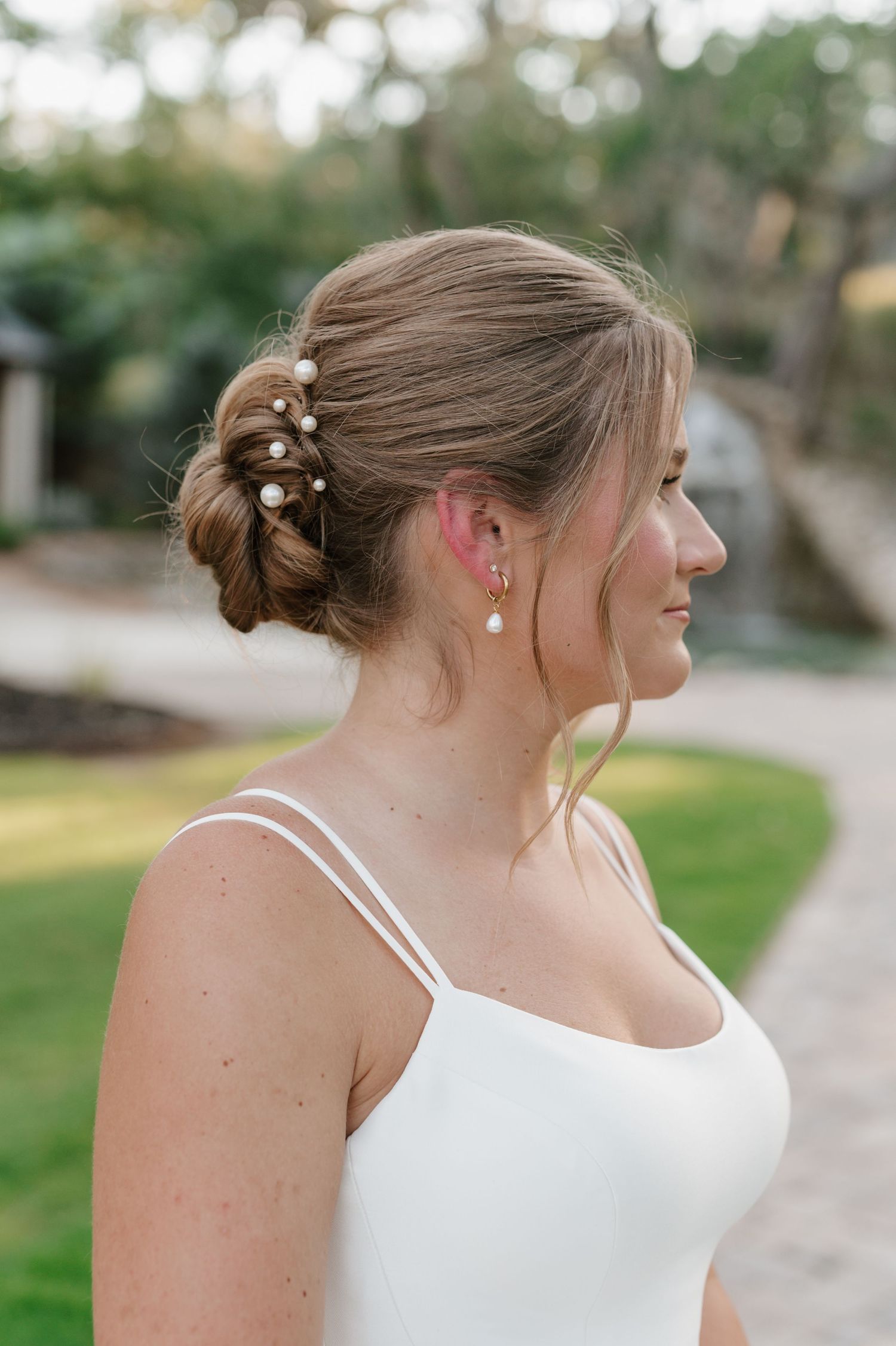 An elegant updo hairstyle adorned with delicate pearl pins captured in soft natural lighting.