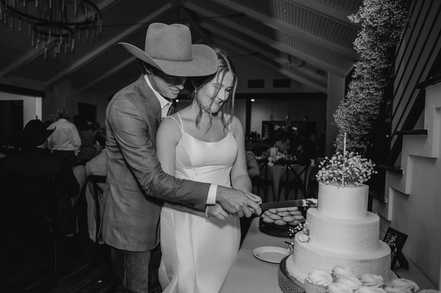 A bride & groom cut their wedding cake at their wedding in the Texas Hill Country photographed by Alyssa Denson Photography.
