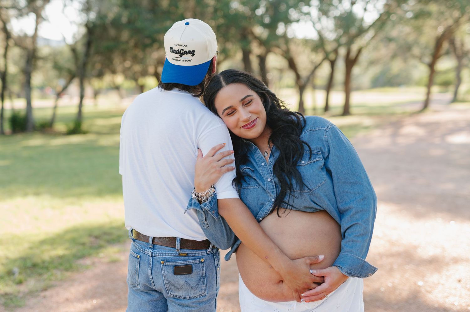 Maternity photo collage showing intimate moments between expecting couple in a park setting wearing coordinating denim outfits.
