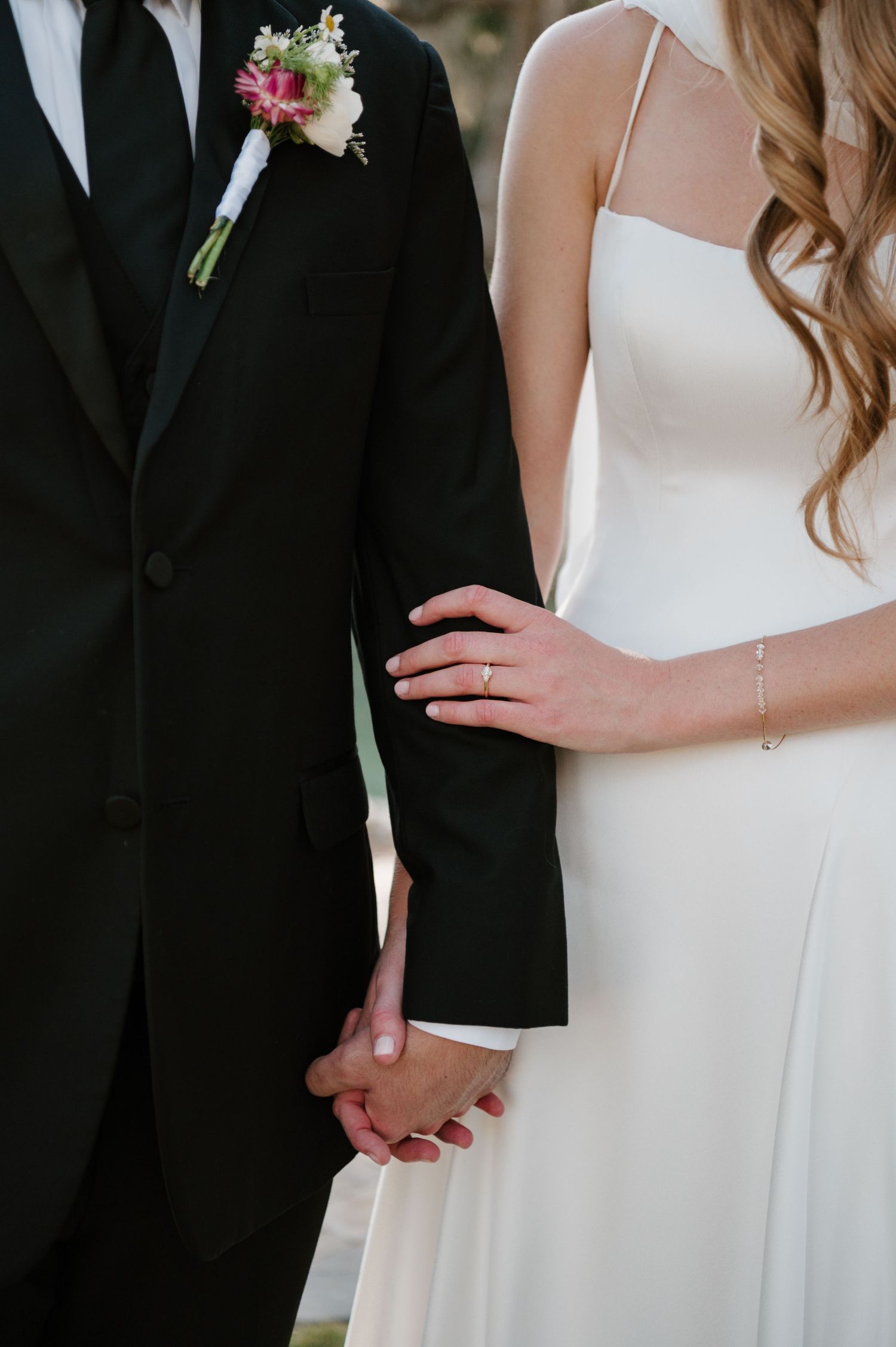 Close-up details of formal wedding attire with delicate floral boutonniere.