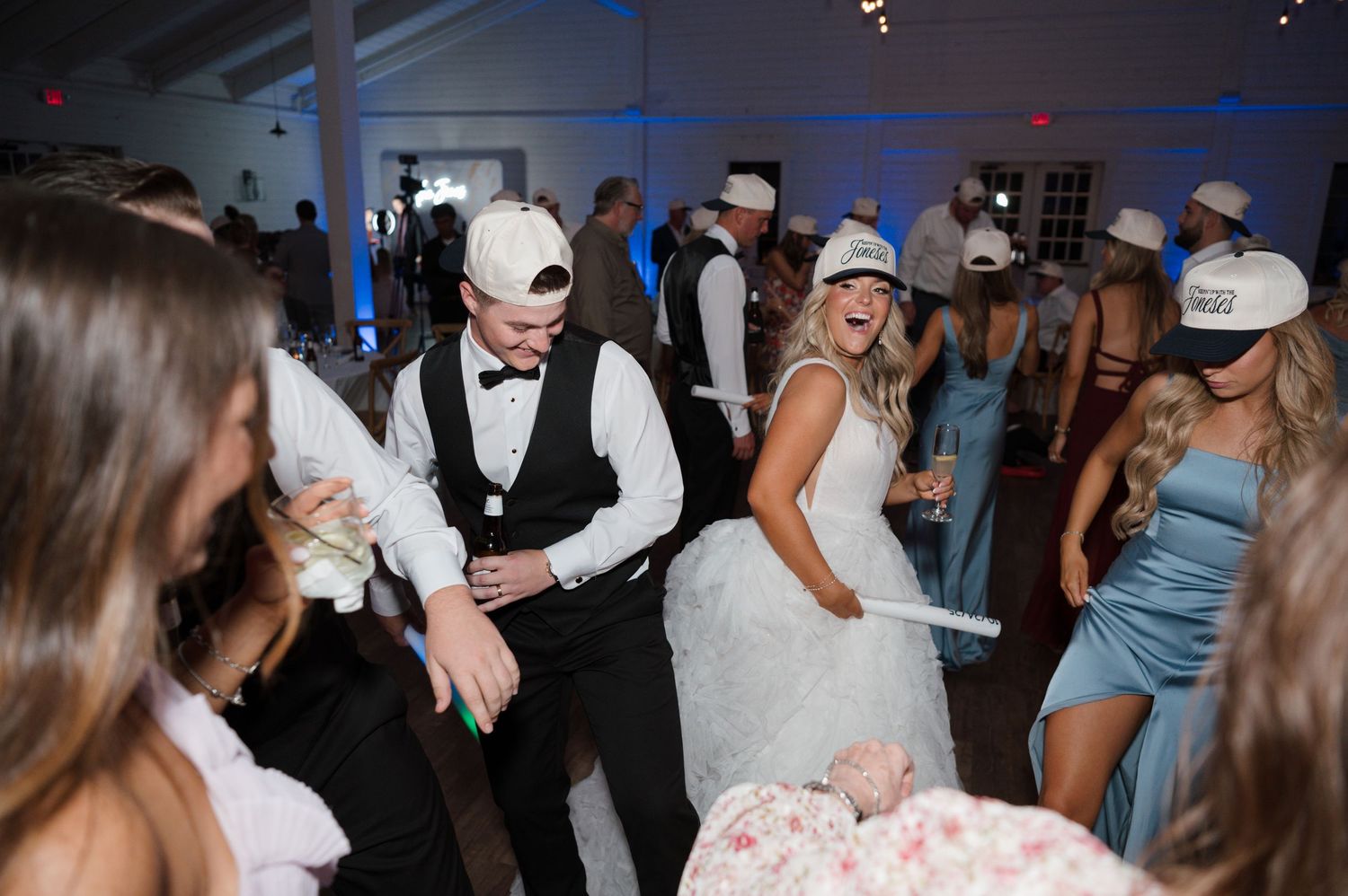 A wedding reception with the bride and groom dancing with their guests in formal attire.