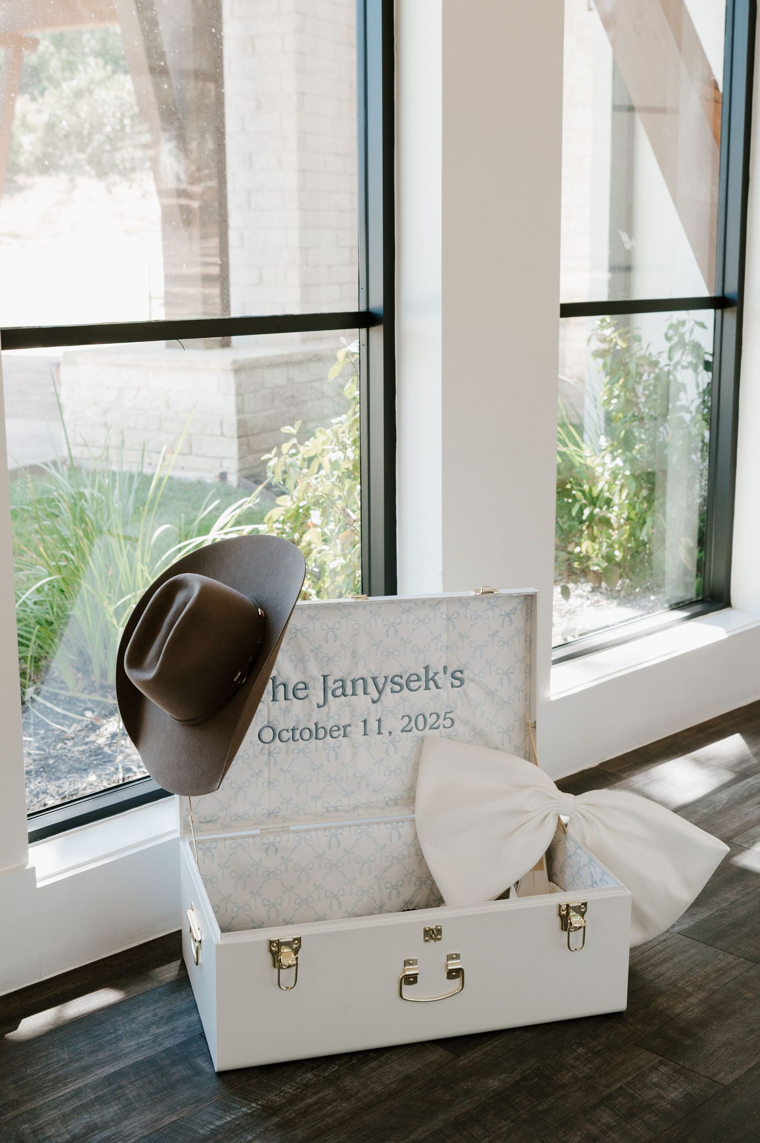 White gift boxes with wedding dates displayed in an elegant window setting.