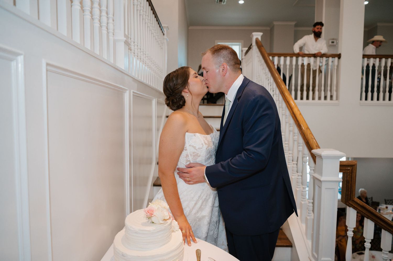 Couple sharing romantic moment in elegant white interior stairway.