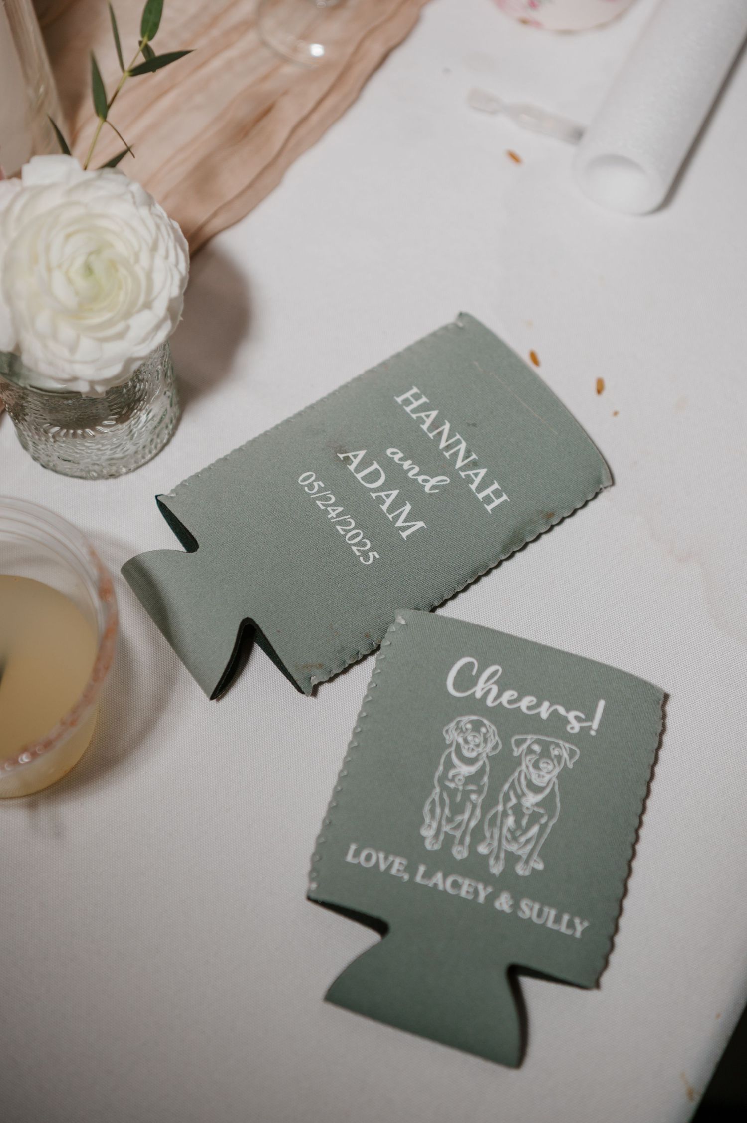 Gray wedding koozies with custom designs and text displayed on white surface.