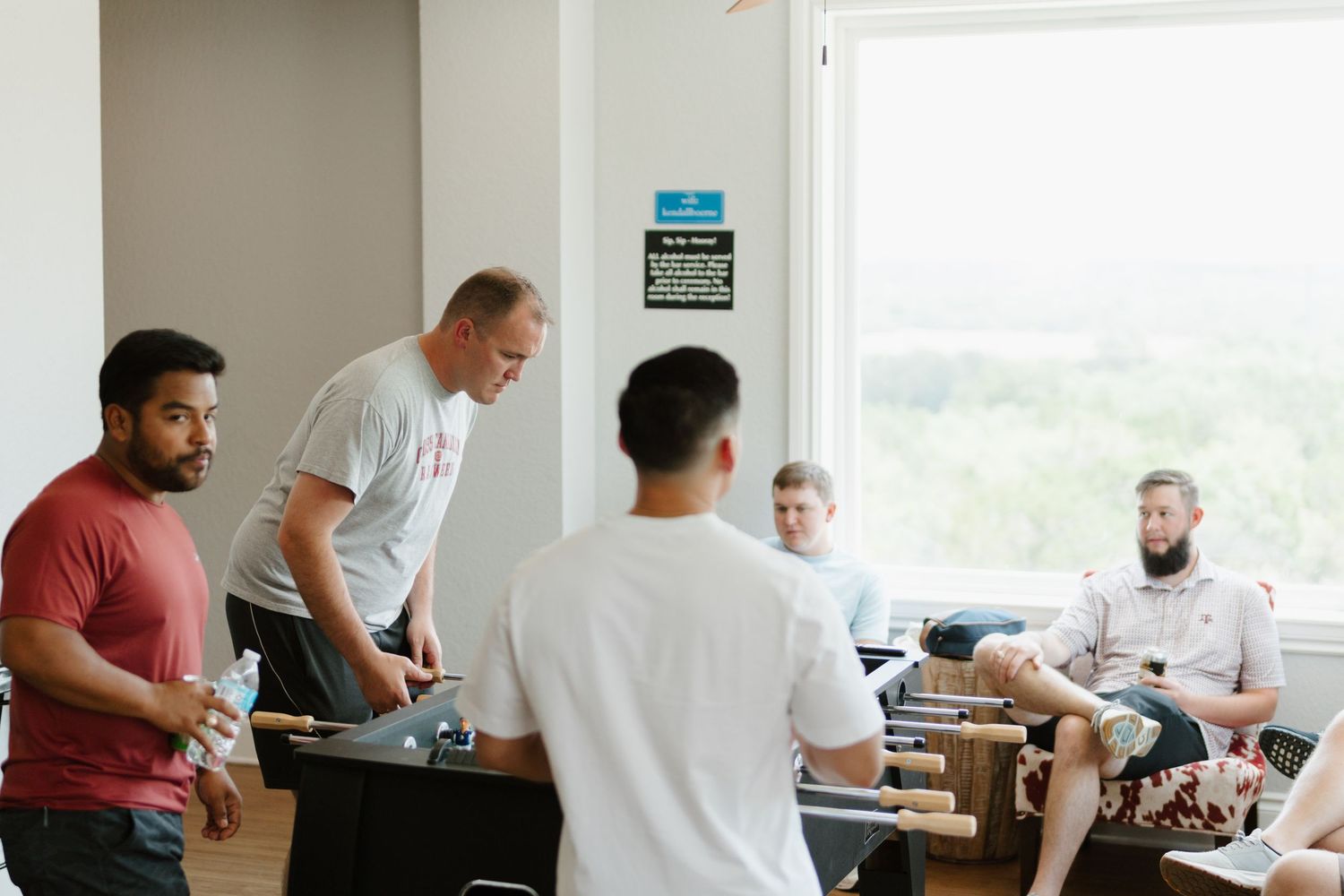 People seated at desks taking notes and working on laptops during a business workshop or training session.