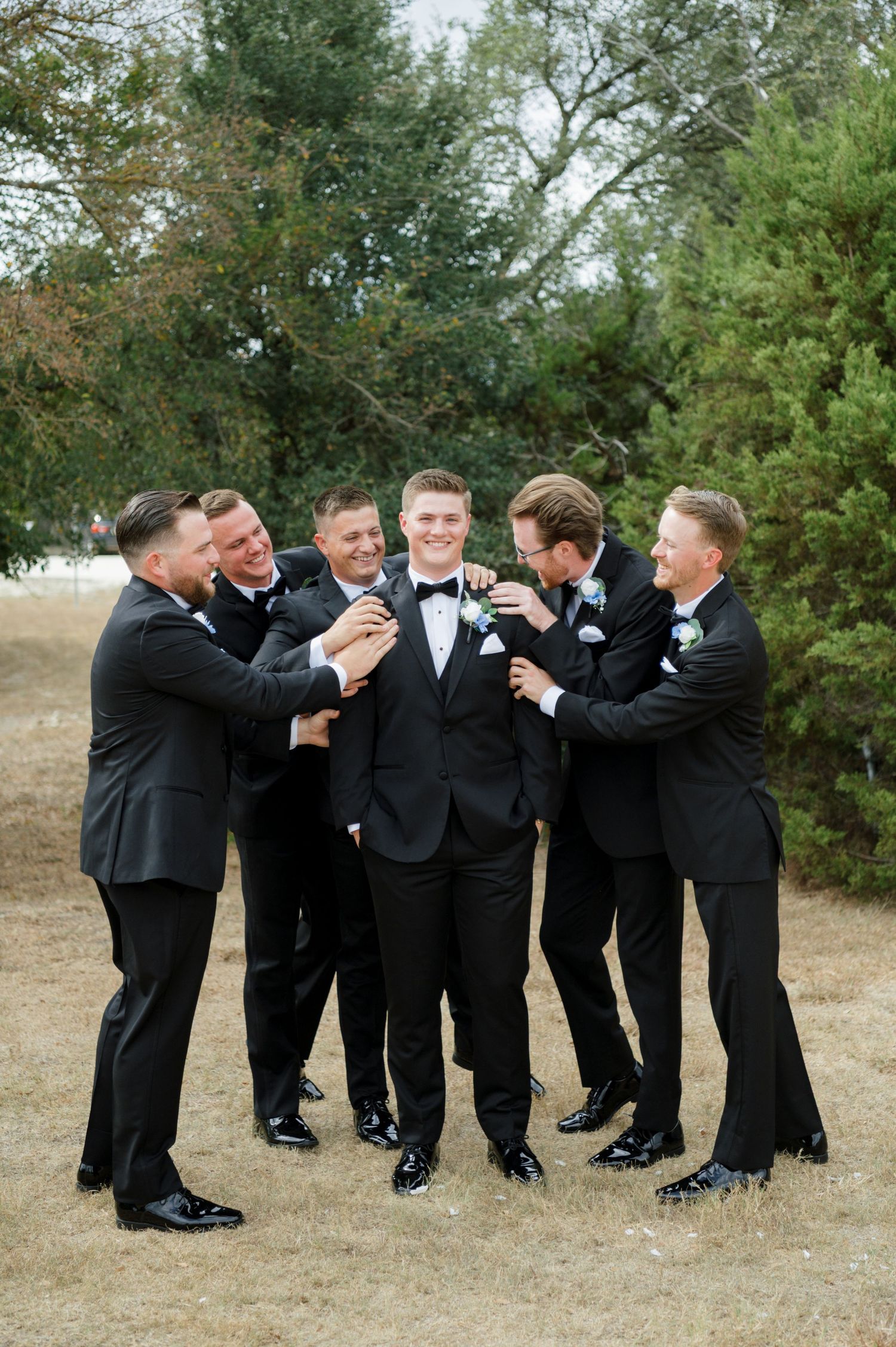 A group of men in formal attire standing together and smiling.