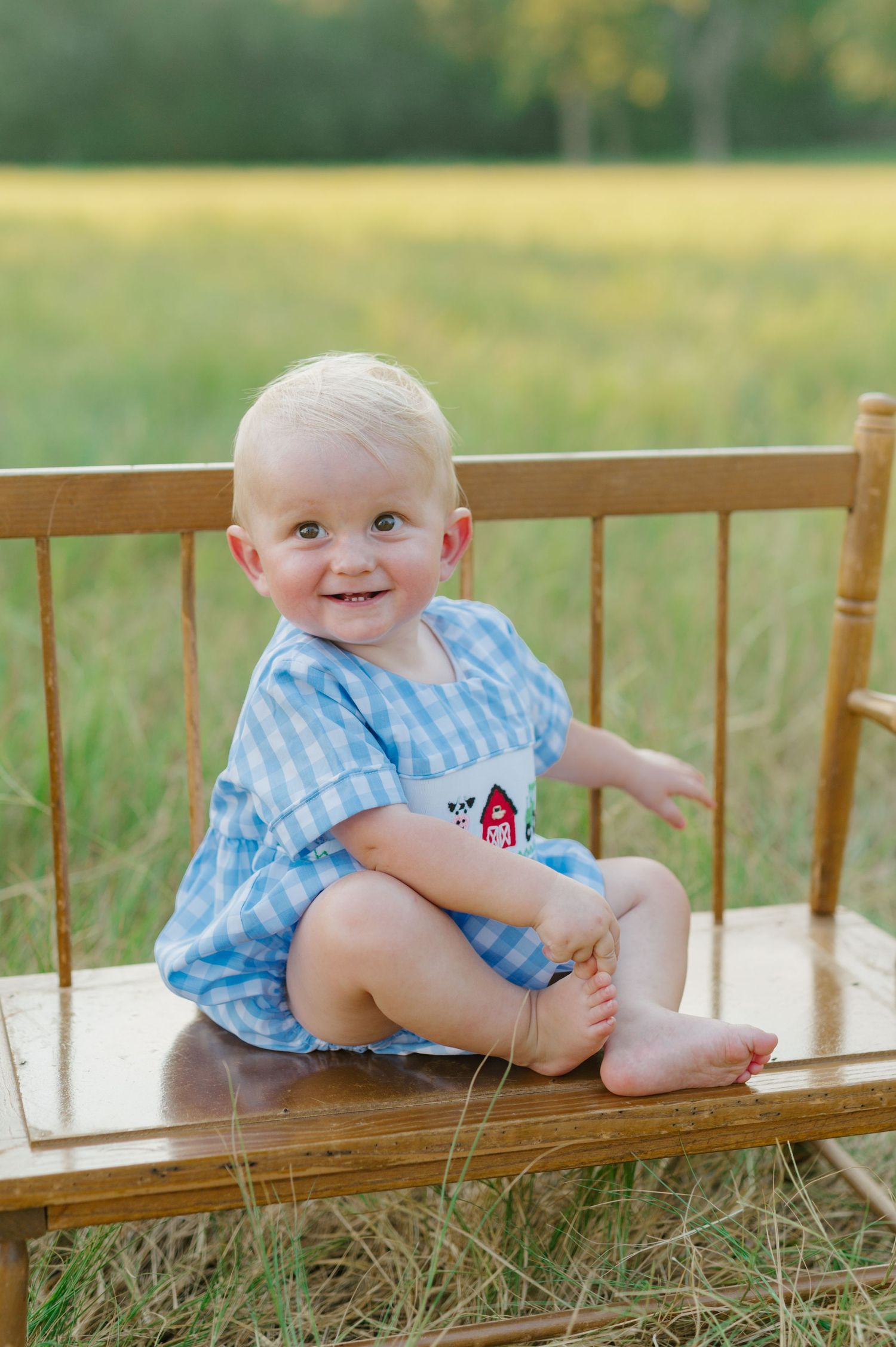 A baby in blue gingham outfit sits on a wooden bench outdoors in a series of connected photos showing different poses.