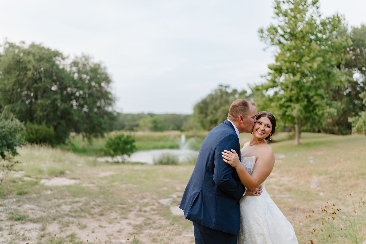 Romantic outdoor wedding portrait session in a natural landscape setting.