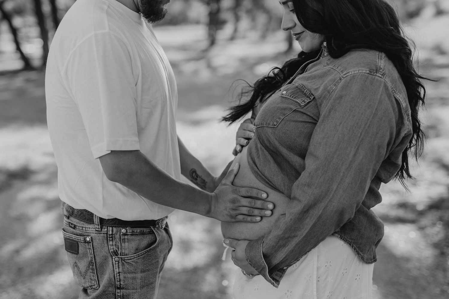 A couple embraces in a romantic photoshoot sequence with trees in the background.