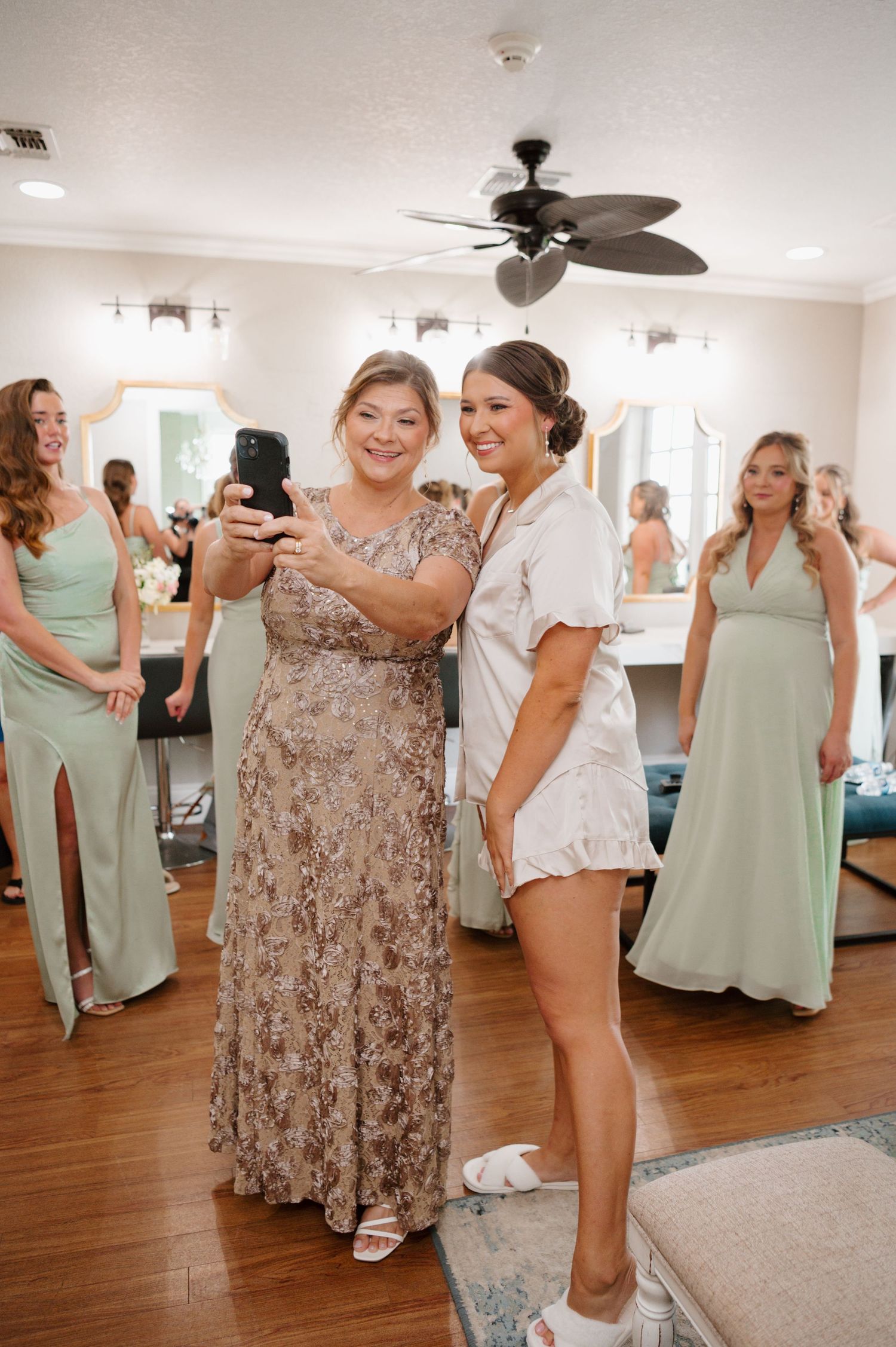 Wedding party dancing and celebrating in a bright room with hardwood floors.