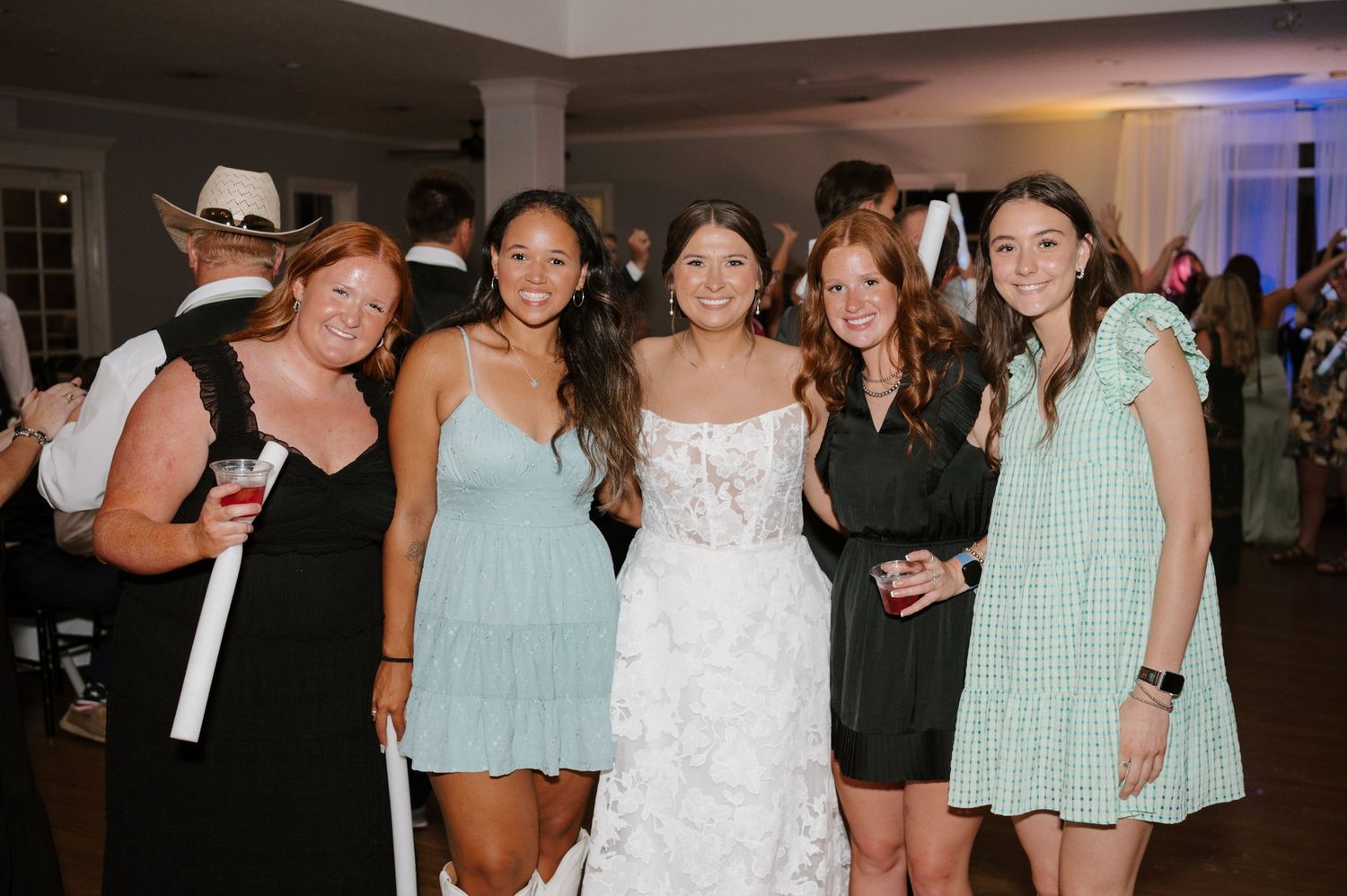 Wedding reception dance floor filled with celebrating guests in evening attire.