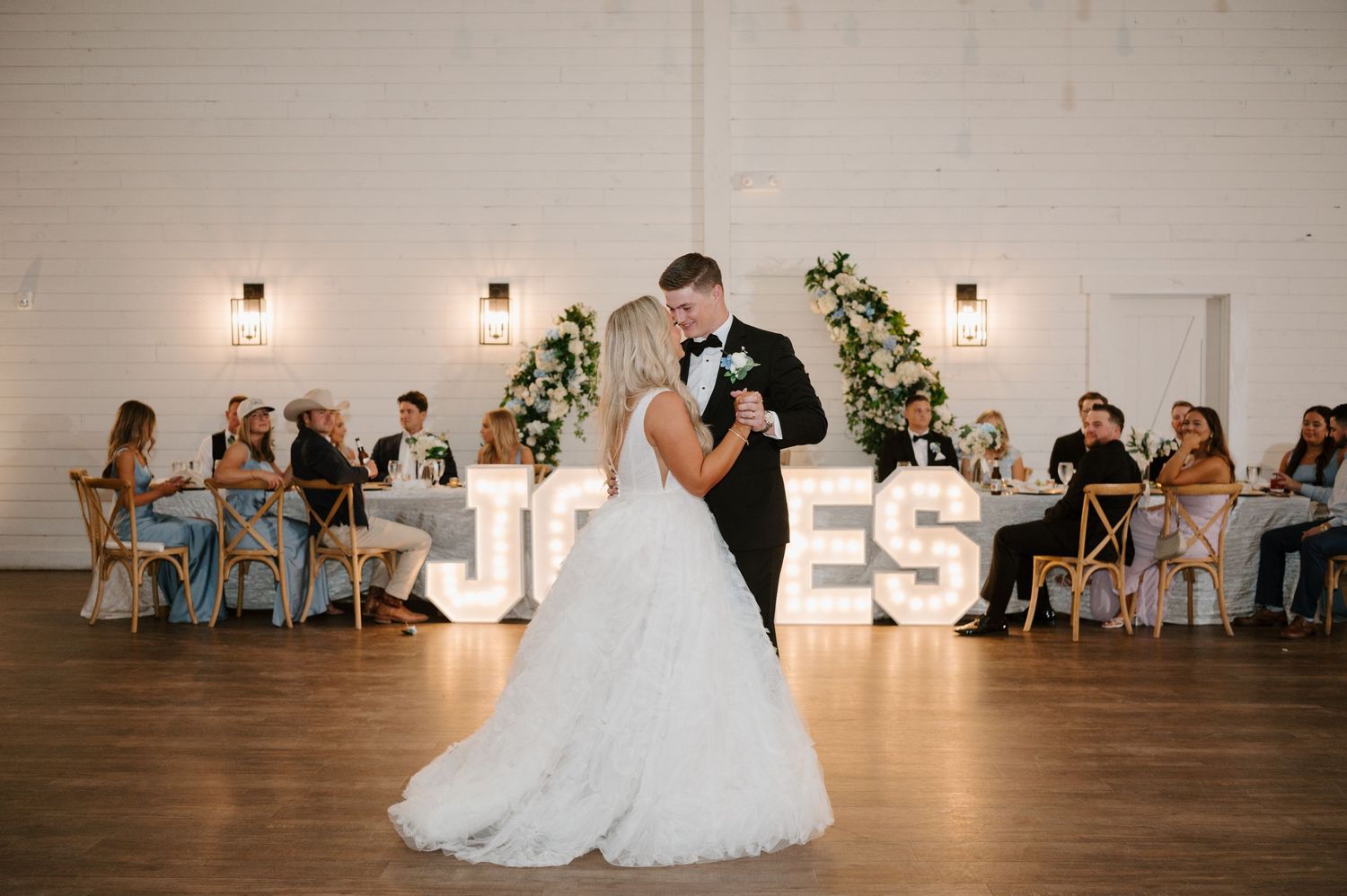 A bride and groom share a romantic dance on the dance floor at their wedding reception.
