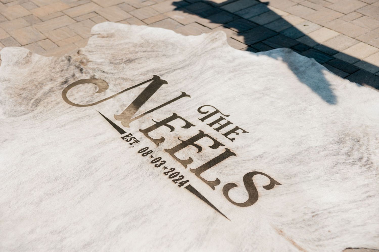 White t-shirt with 'The Feels' text logo printed in brown on fabric.
