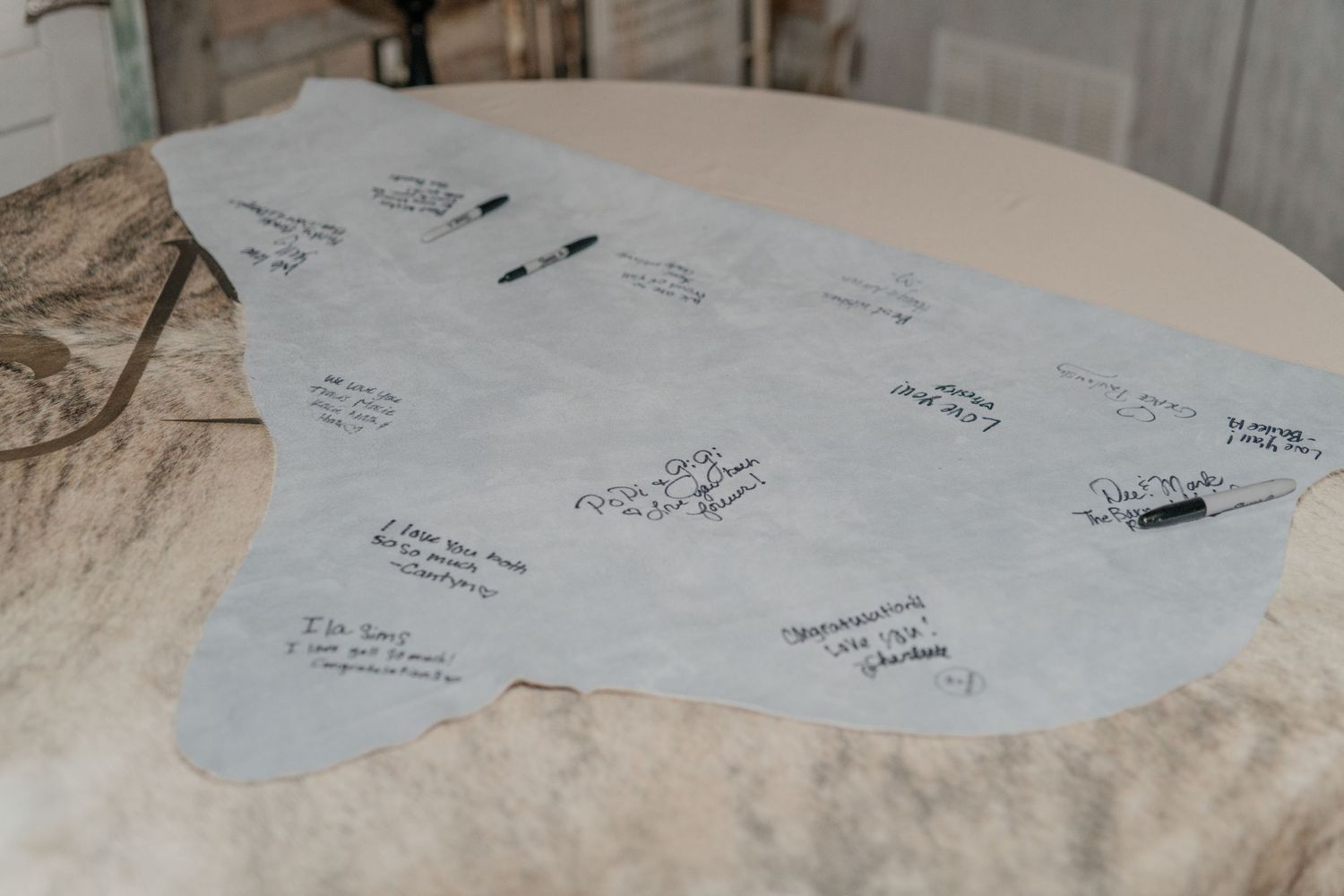 Wedding guest book alternative showing gray state-shaped cutout with signatures.