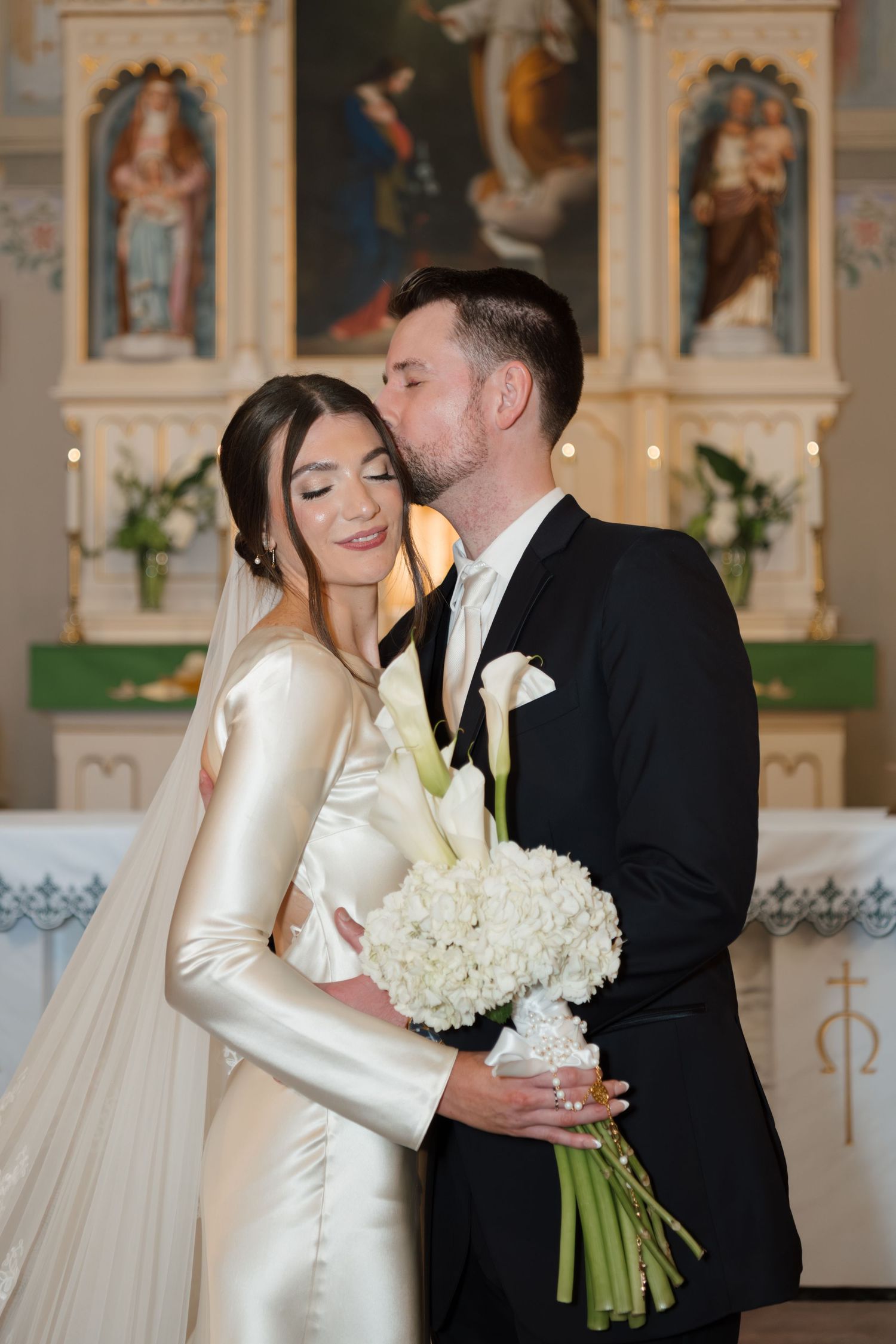 Elegant church wedding ceremony with white floral arrangements and traditional decor.