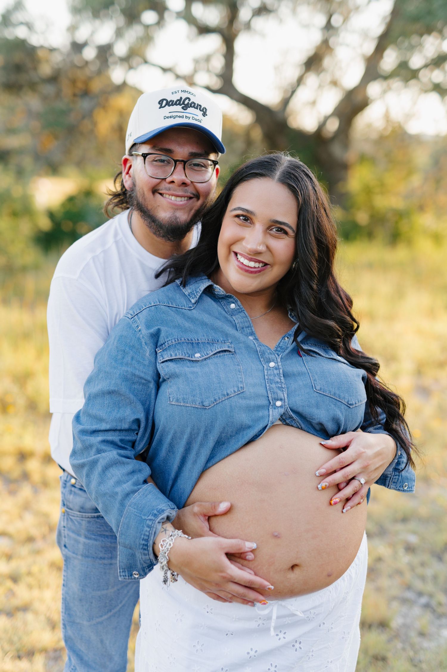 Joyful maternity photos taken outdoors show couple celebrating their pregnancy journey together.
