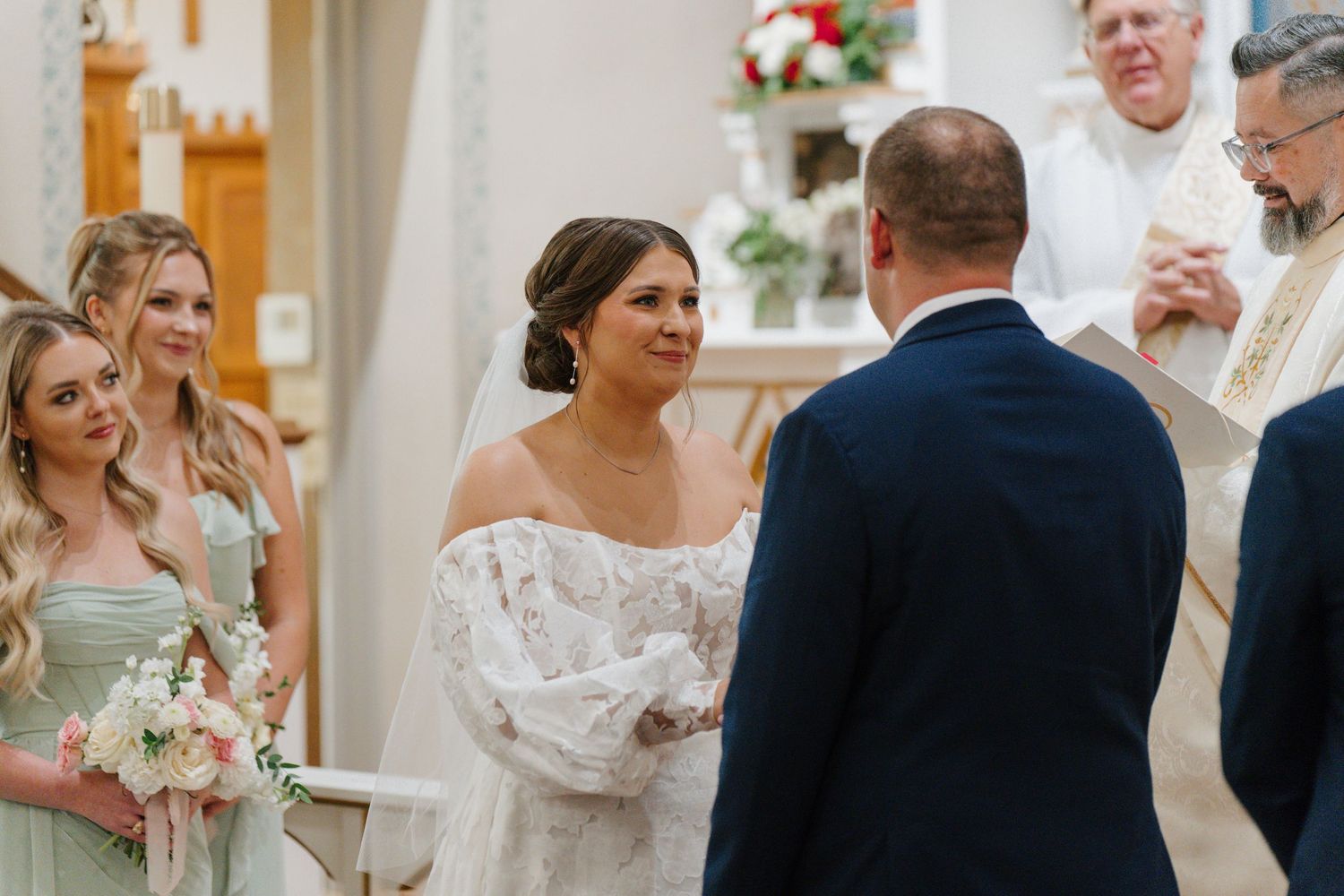 Wedding ceremony participants gather in a traditional church setting with ornate decor.