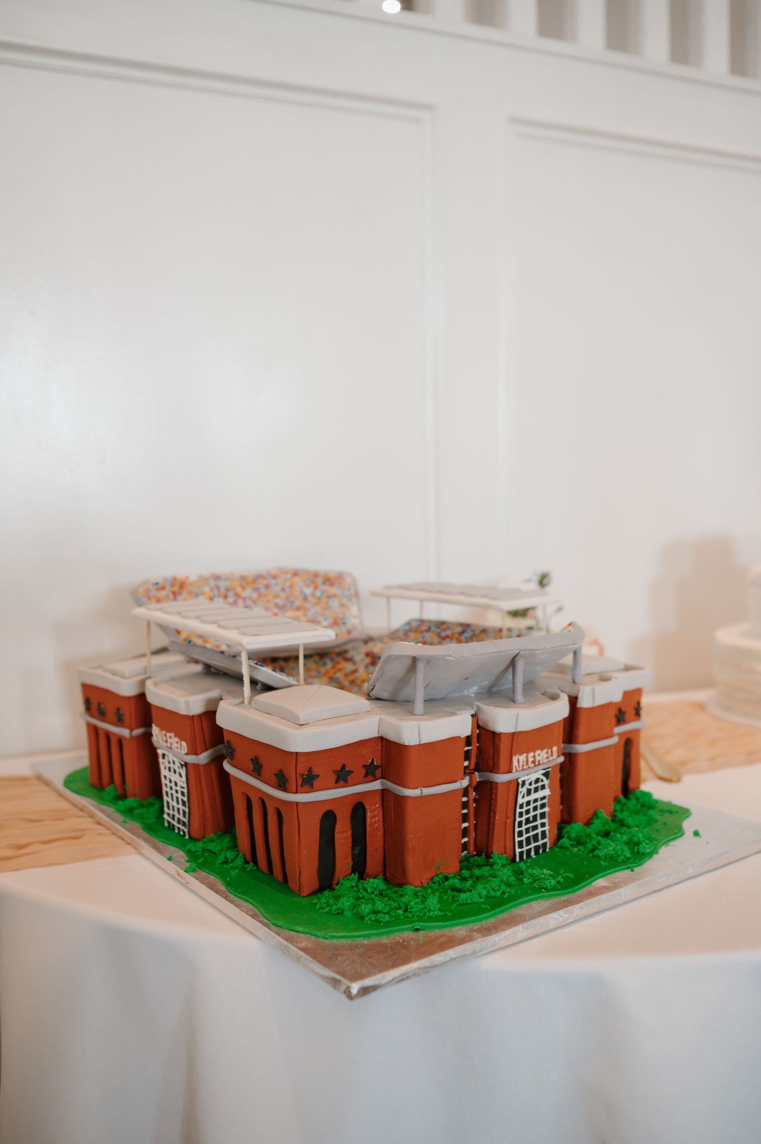 Architectural model of a red brick building complex displayed on white surface.