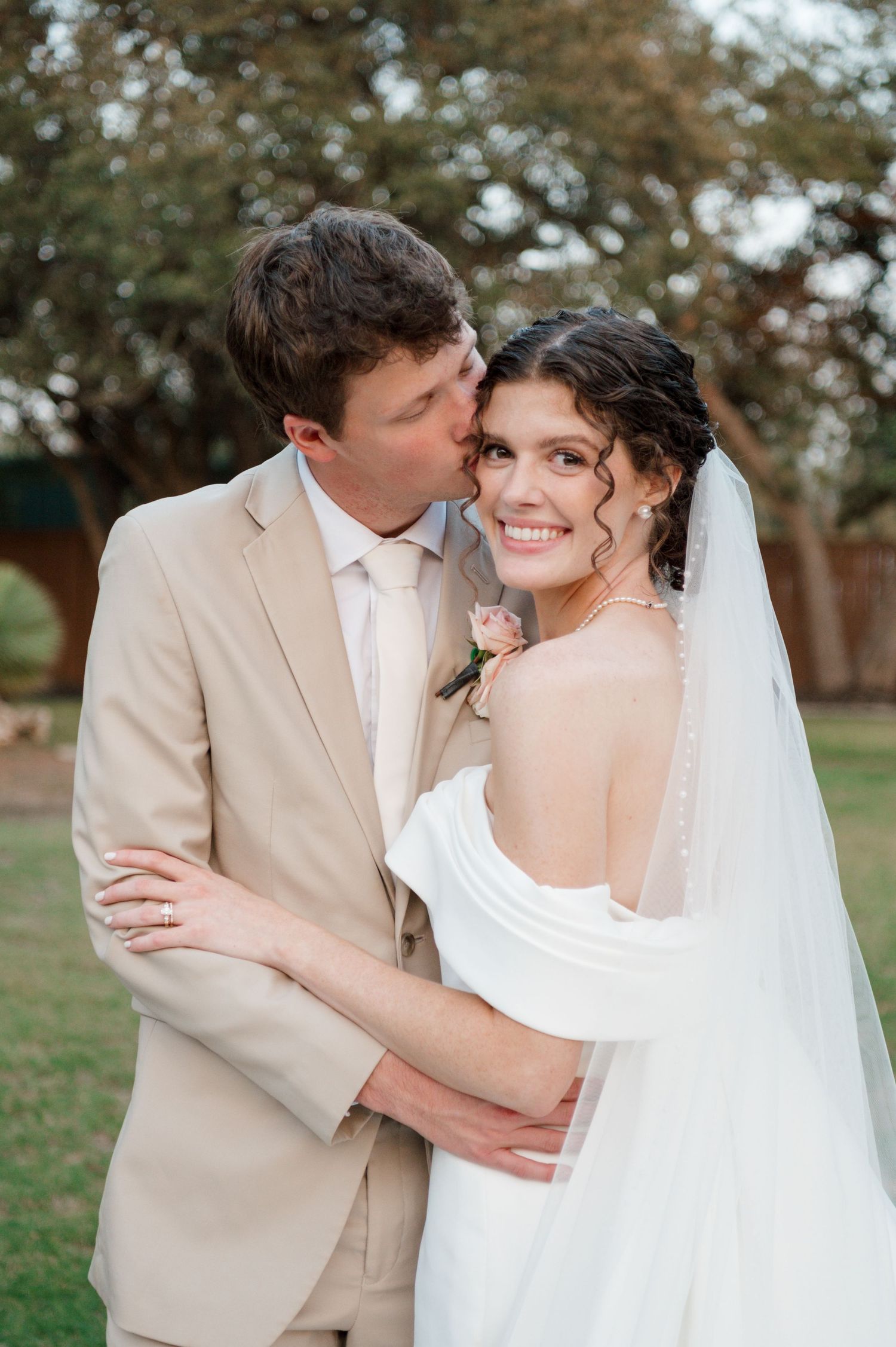 A romantic outdoor wedding photoshoot showing tender moments between a bride in white and groom in beige.