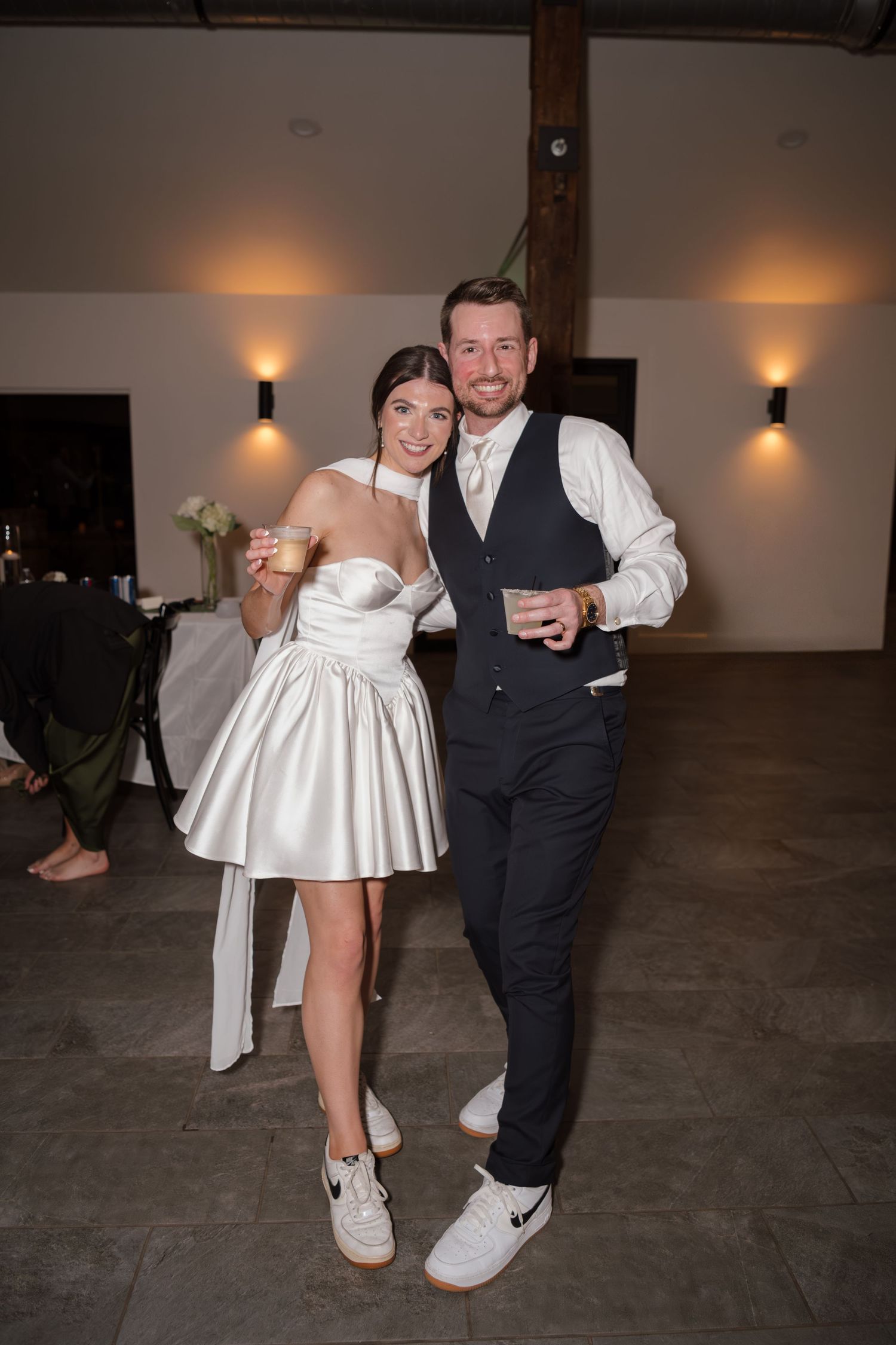 Wedding reception dance floor showing white dress and formal attire in dimly lit venue.