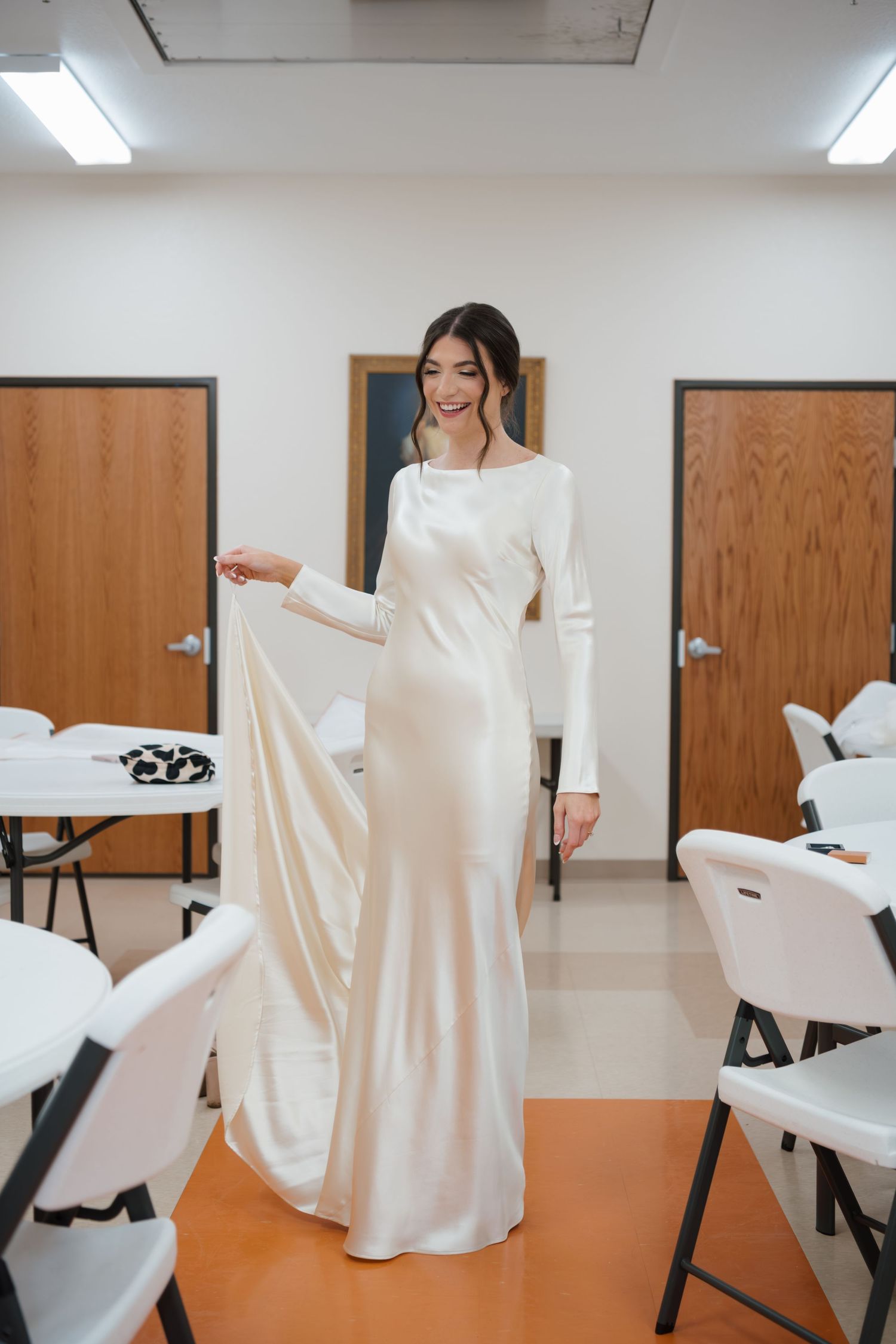 A person in a flowing white dress spins and twirls in a sequence of dance-like movements across a room.