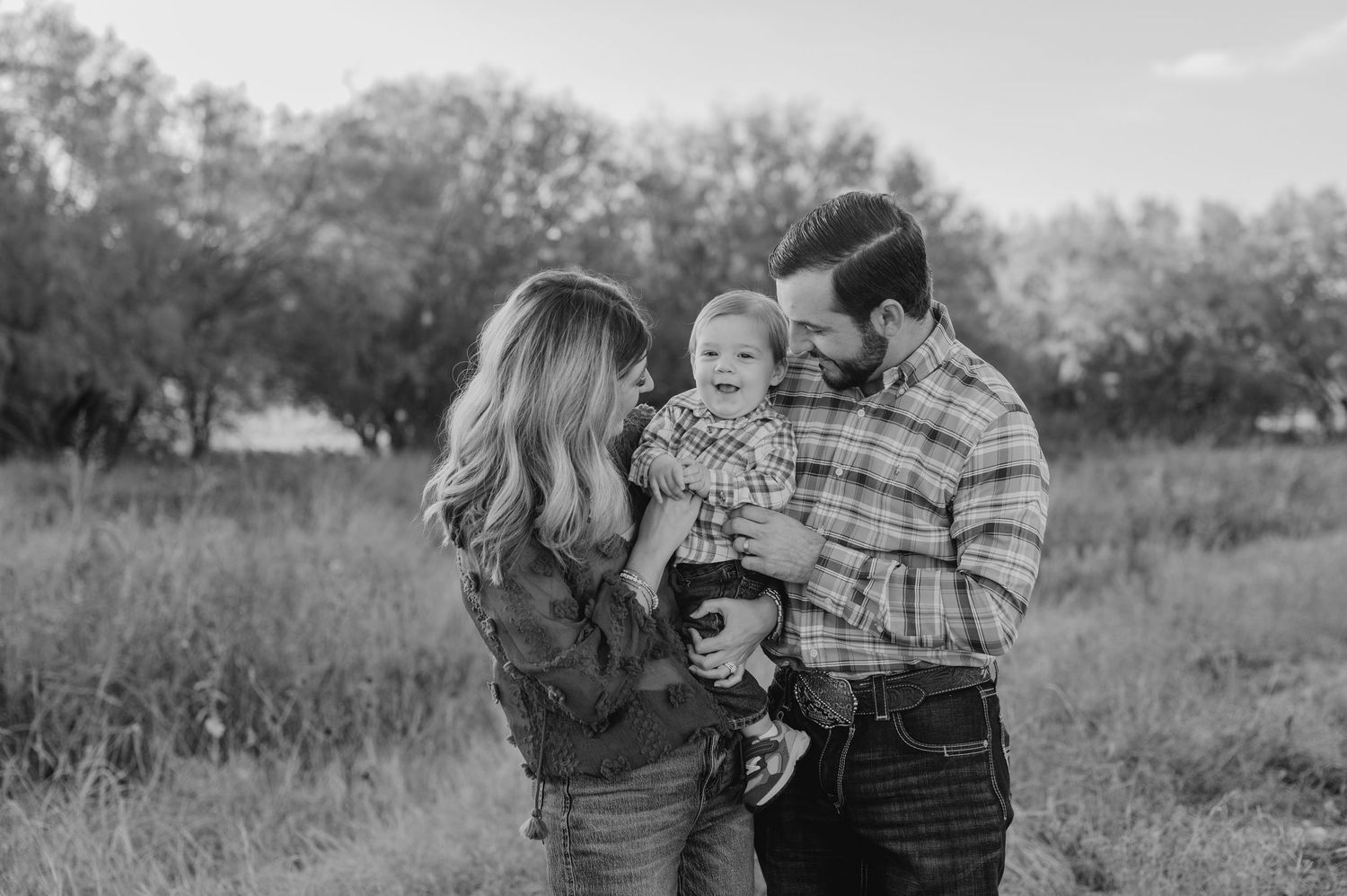 A series of black and white photos showing tender moments between a couple in a natural outdoor setting.