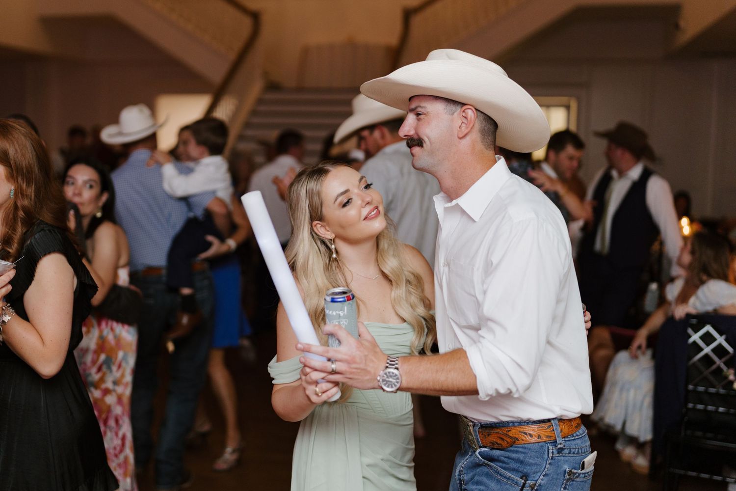 Wedding guests dancing and celebrating at reception party.