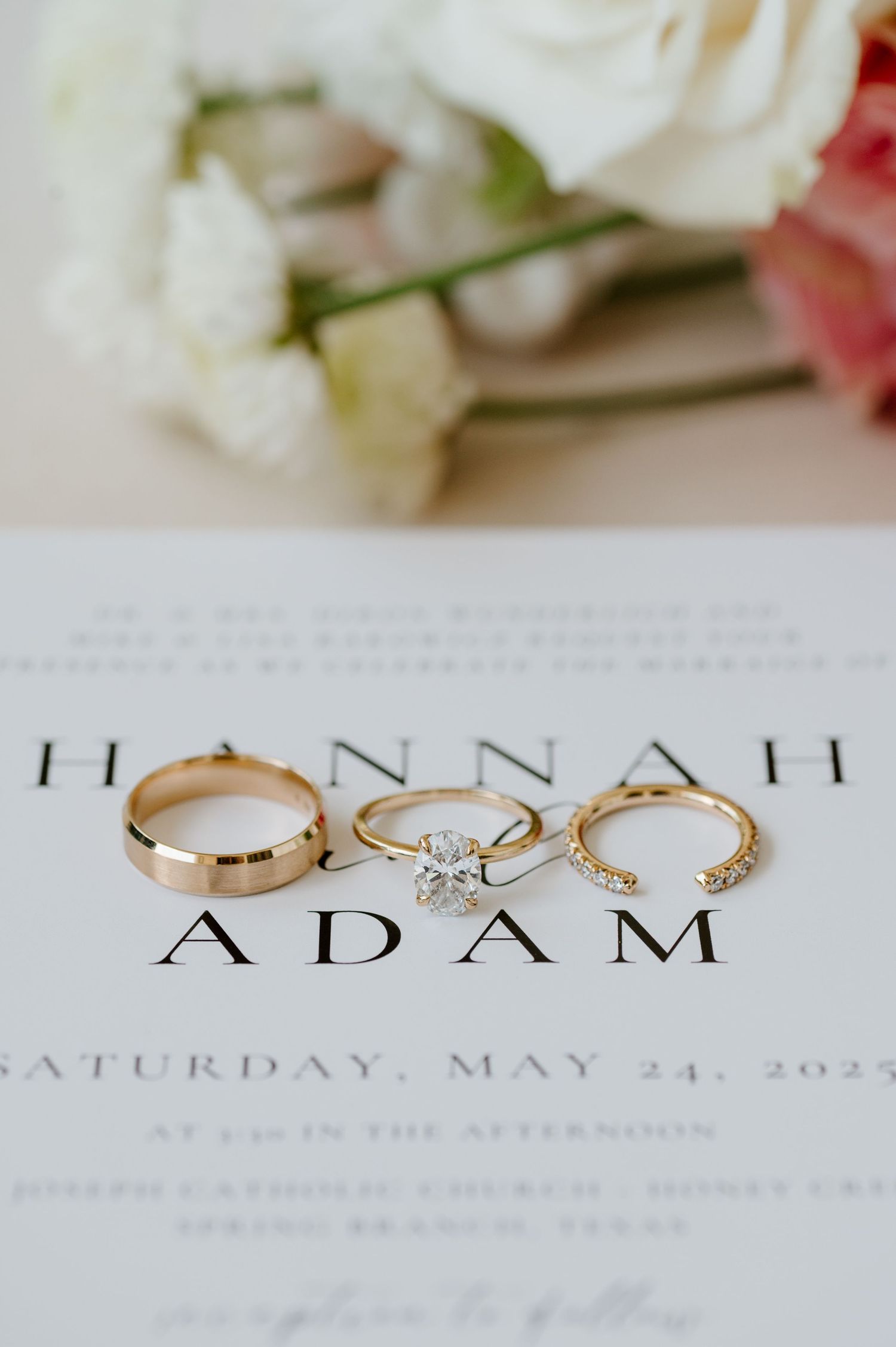 Wedding invitation and elegant gold engagement ring with diamond on white paper.