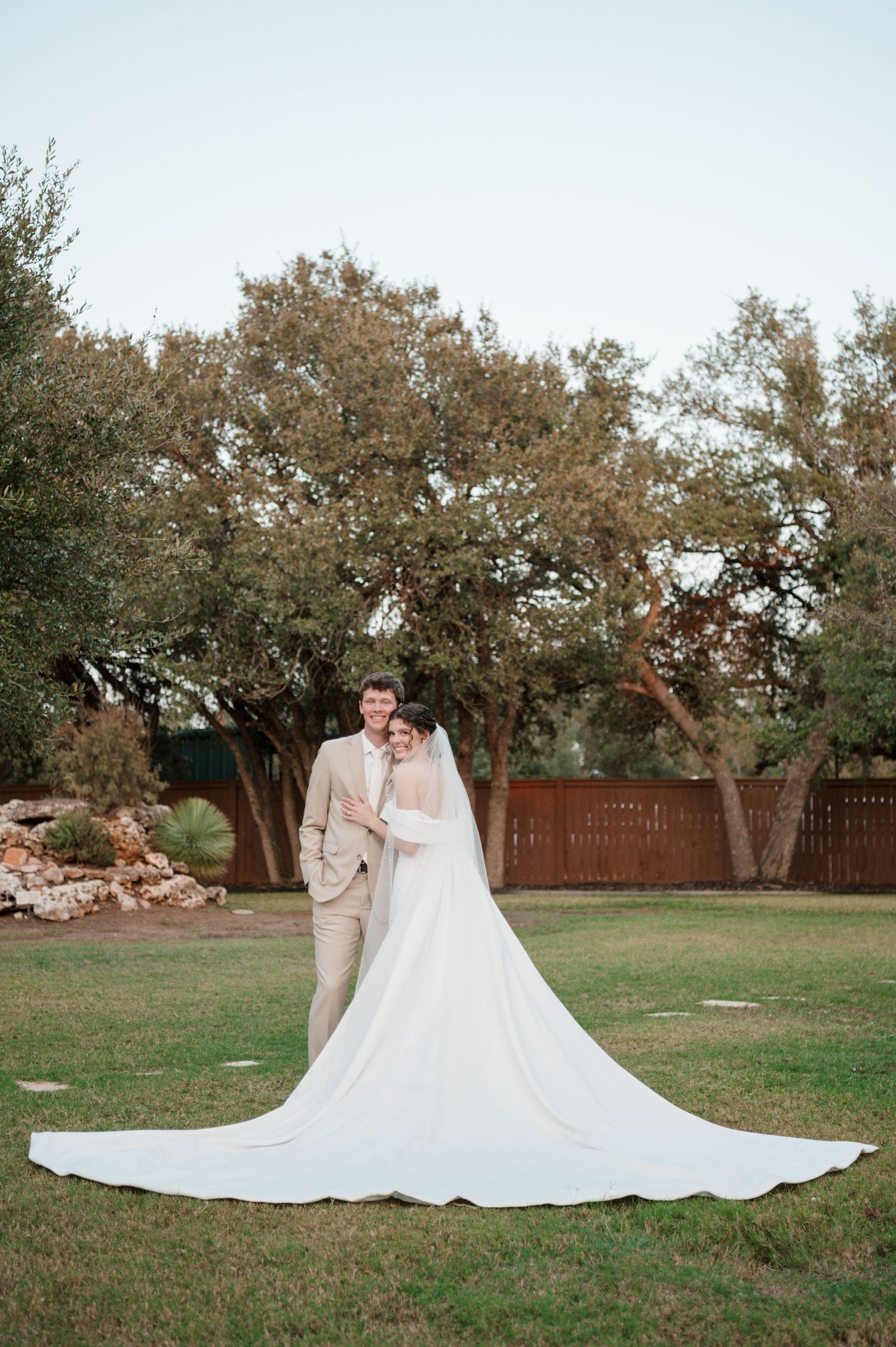 A stunning wedding photo series showing a bride's dramatic cathedral-length train flowing across a grassy lawn.